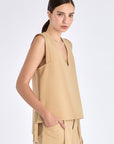 Side view of the Camel Valencia Blouse, with a focus on the adjustable buckle at the hem.