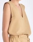 Side view of the Camel Valencia Blouse, with a focus on the adjustable buckle at the hem.