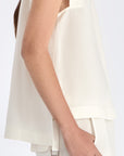 Side view of the Off White Valencia Blouse, with a focus on the adjustable buckle at the hem.