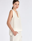 Side view of the Off White Valencia Blouse, with a focus on the adjustable buckle at the hem.