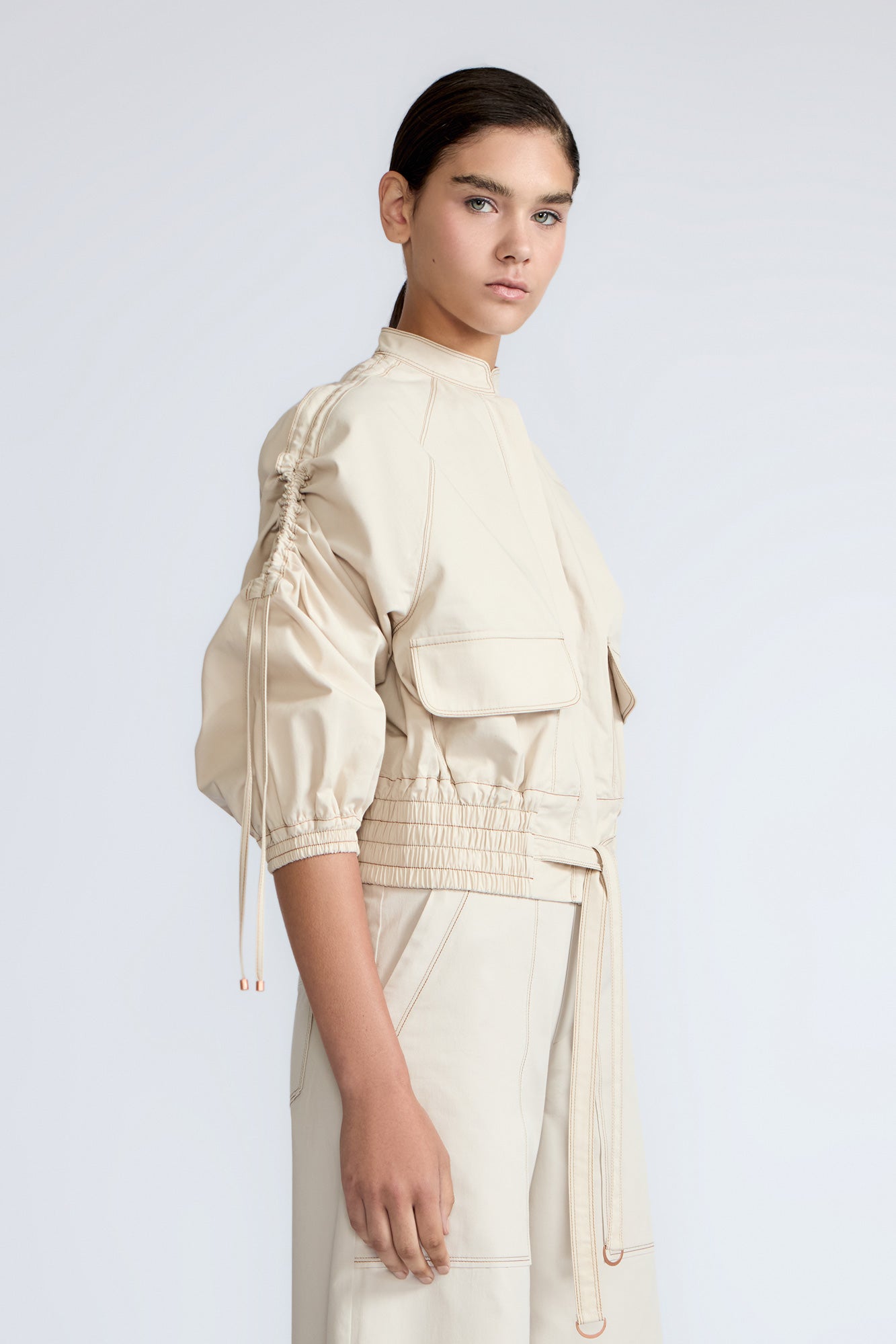 Zoe Jacket in Prestine – 100% cotton jacket with flap patch pockets, hidden buttons, long sleeves, and an adjustable drawstring hem.