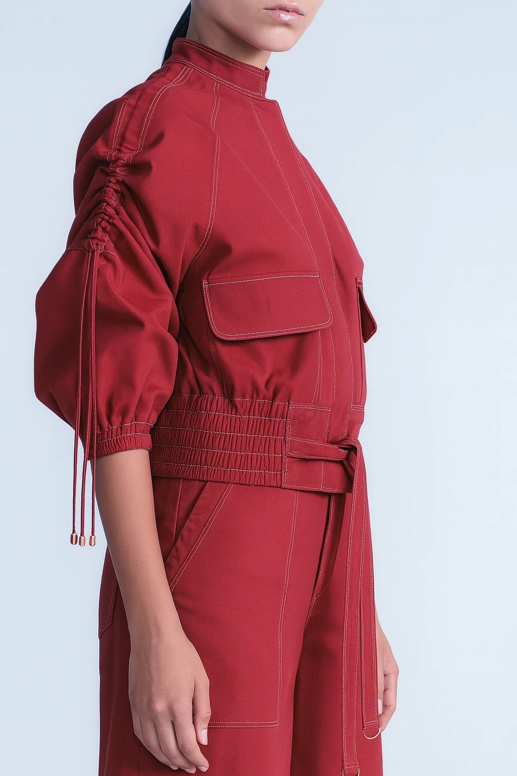 Red outfit with a high collar and puff sleeves on a light blue background