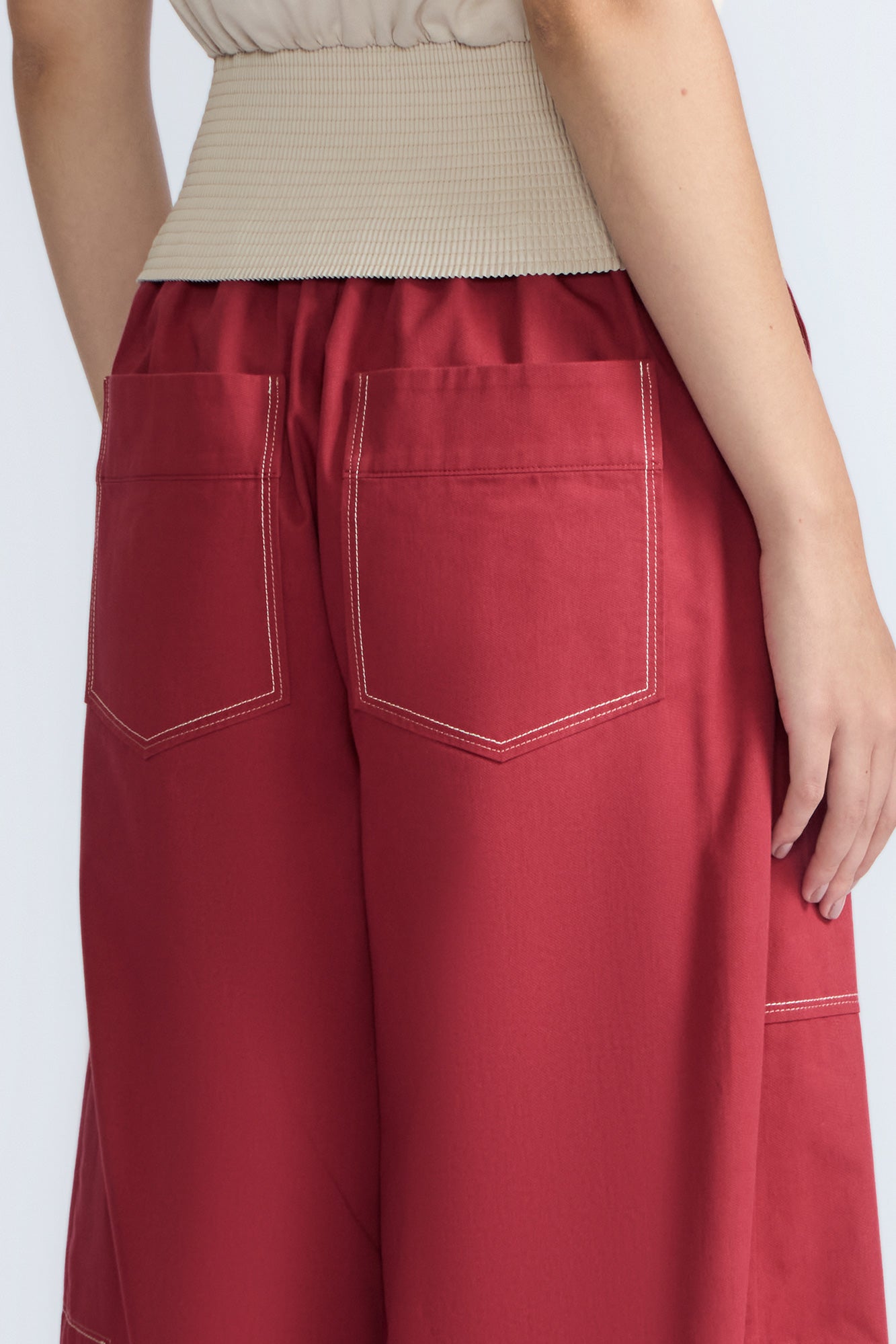 Zoe Pant in Wine – High-waisted wide-leg pants with front and back patch pockets, contrast stitching, and side vents.