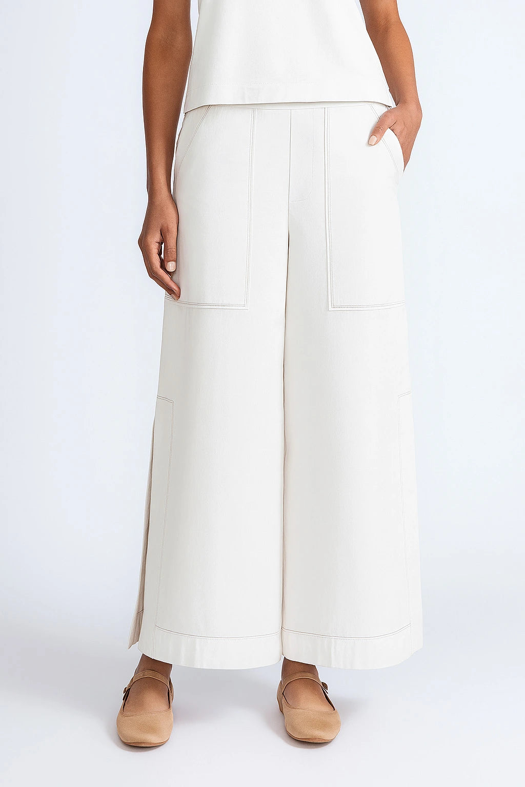 Person wearing white wide-leg pants on a plain background