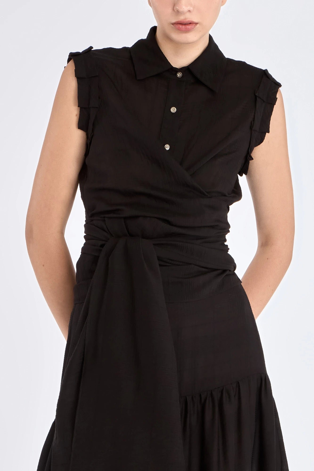 The Harlow Wrap Blouse in black, detailed with its polished metal buttons.