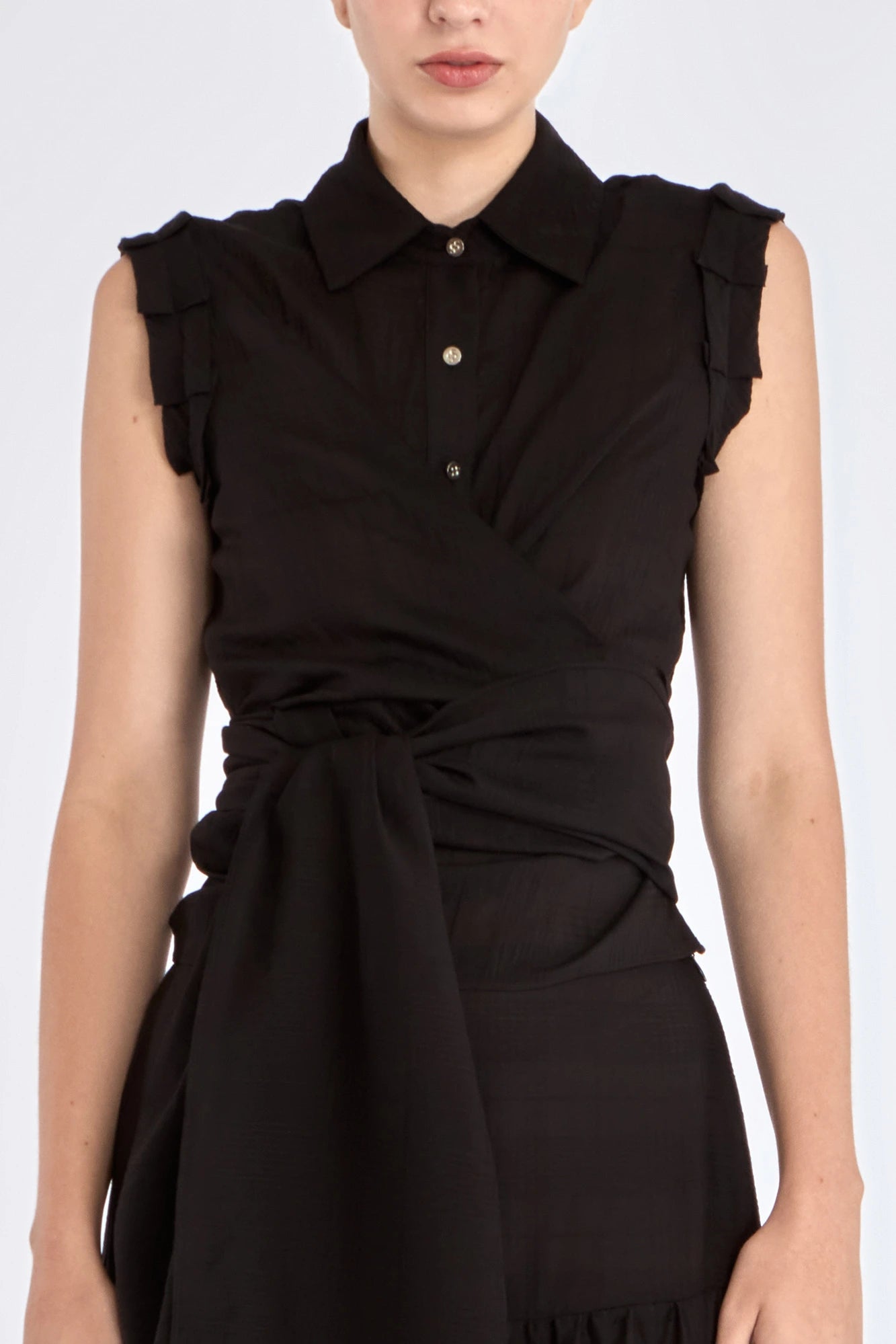 The Harlow Wrap Blouse in black, detailed with its polished metal buttons.