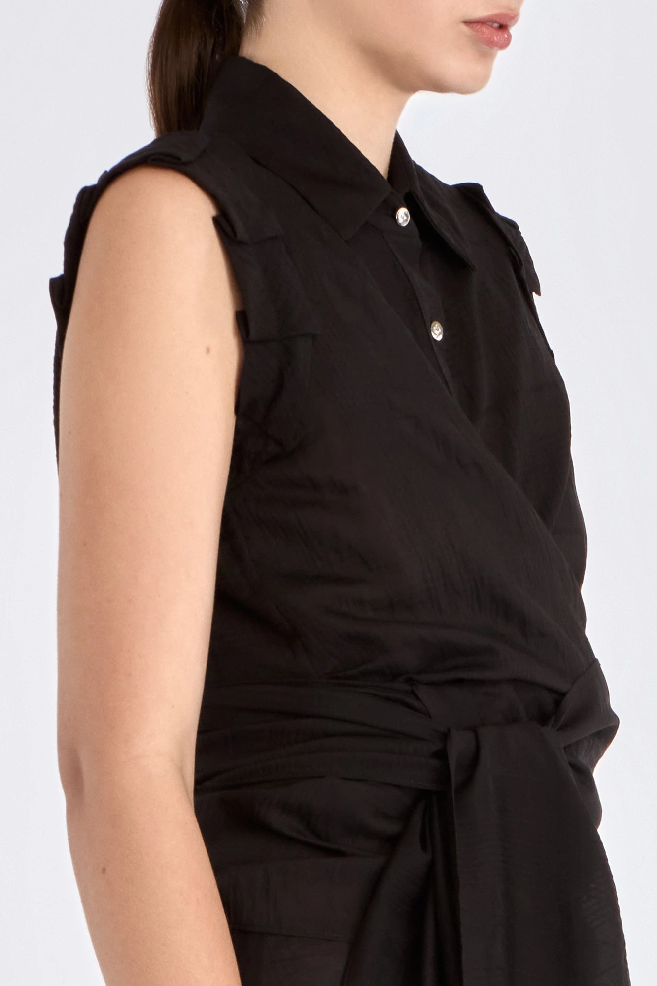 The Harlow Wrap Blouse in black, detailed with its polished metal buttons.
