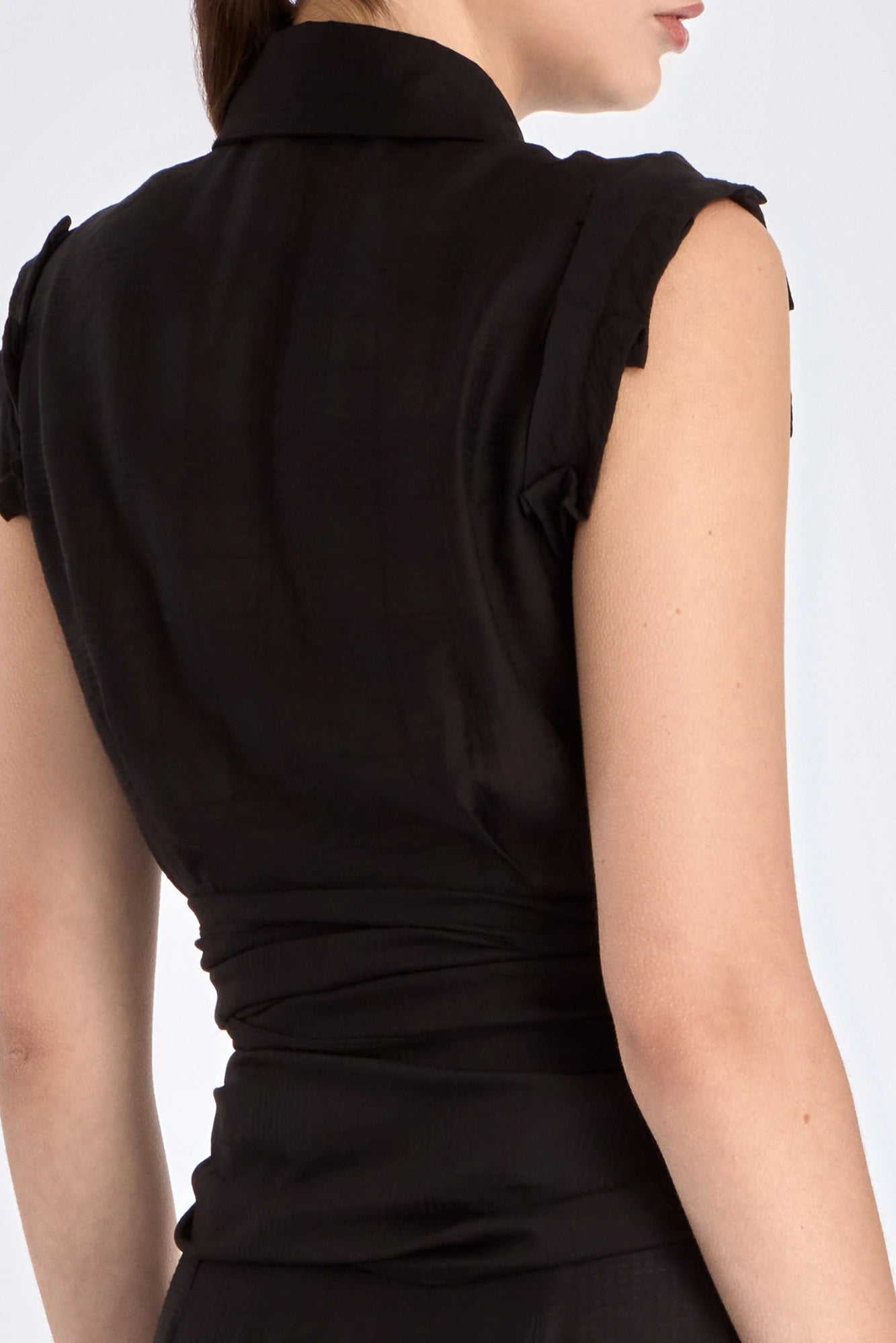 The Harlow Wrap Blouse in black, detailed with its polished metal buttons.