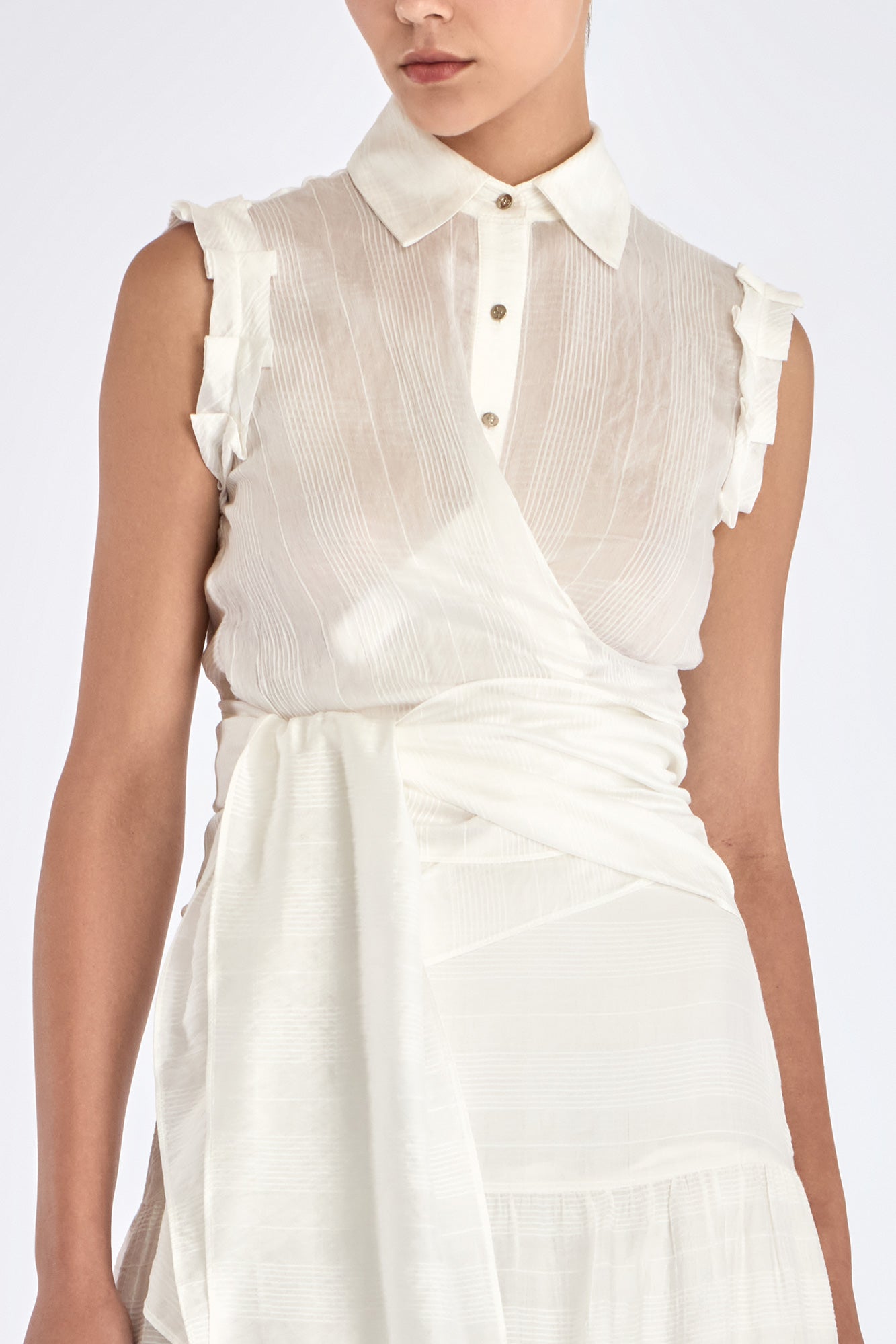 Close-up detail of the signature metal button on the Harlow Blouse.