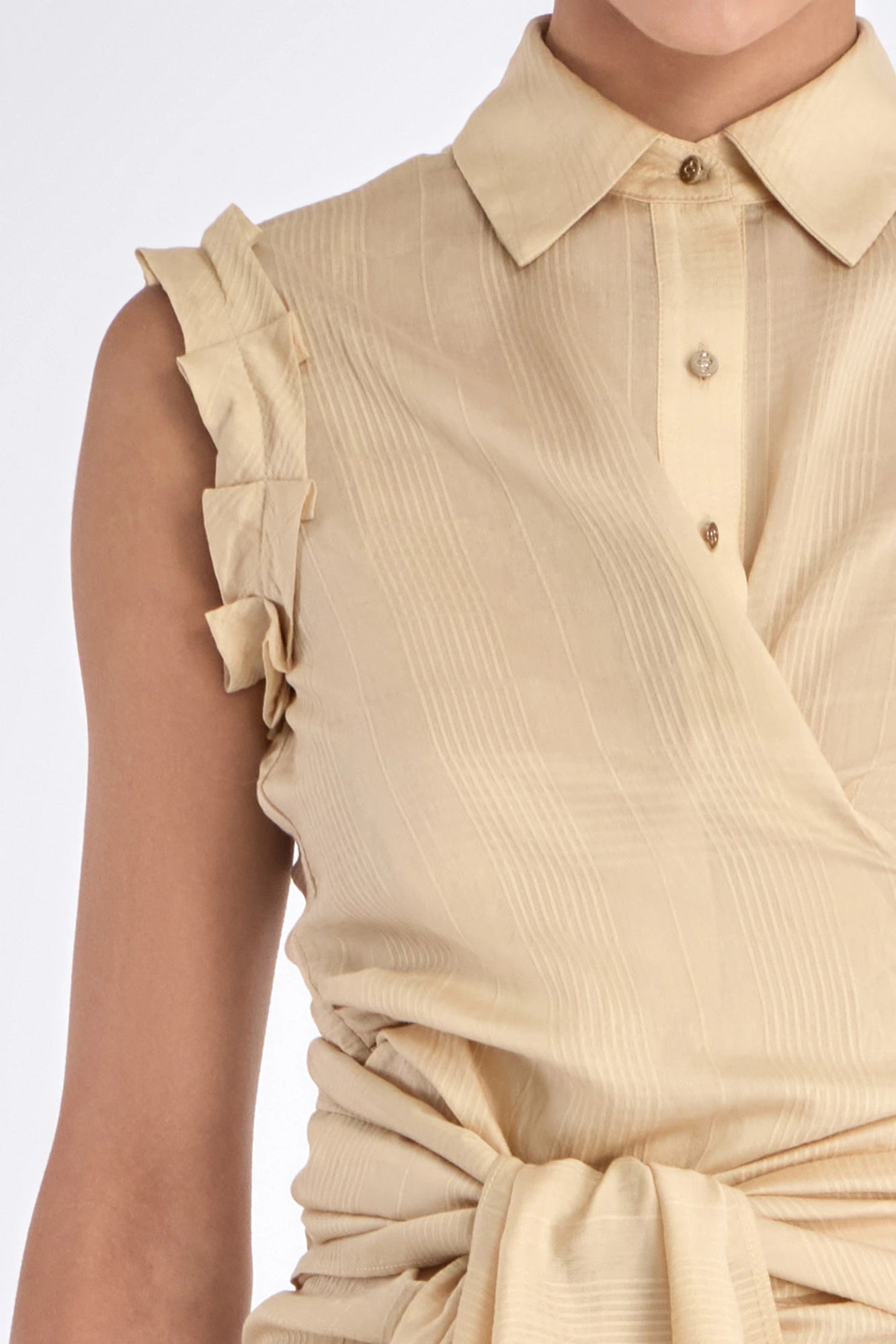 Elegant details of the vanilla Harlow Blouse, showing the shoulder pleats and wrap design.