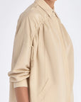 Side profile of the Ailani Jacket in a natural Ecru, featuring its unique drawstring placket.