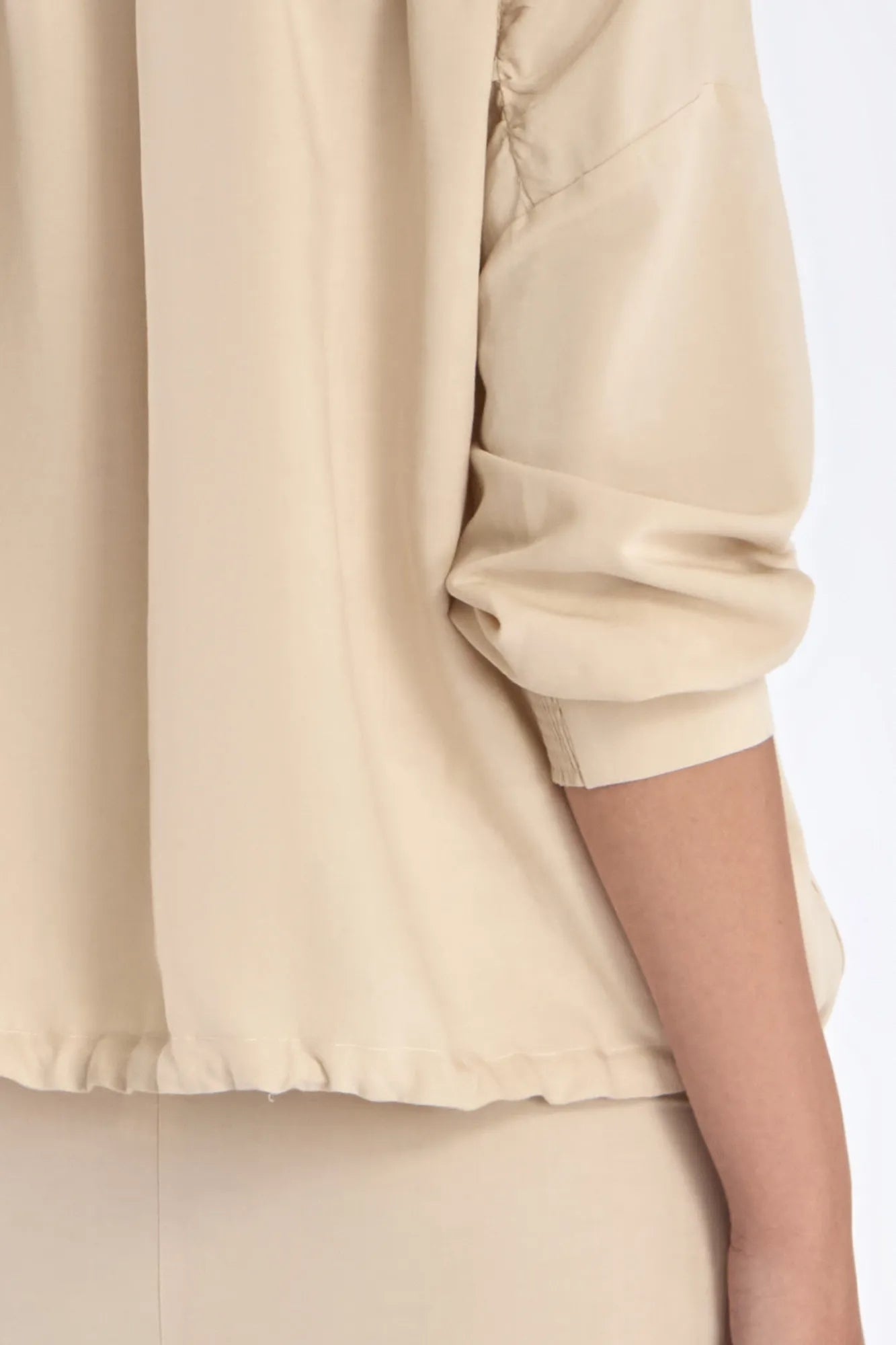 Close-up of the signature metal button and the natural texture of the linen blend on the Ecru Ailani Jacket.