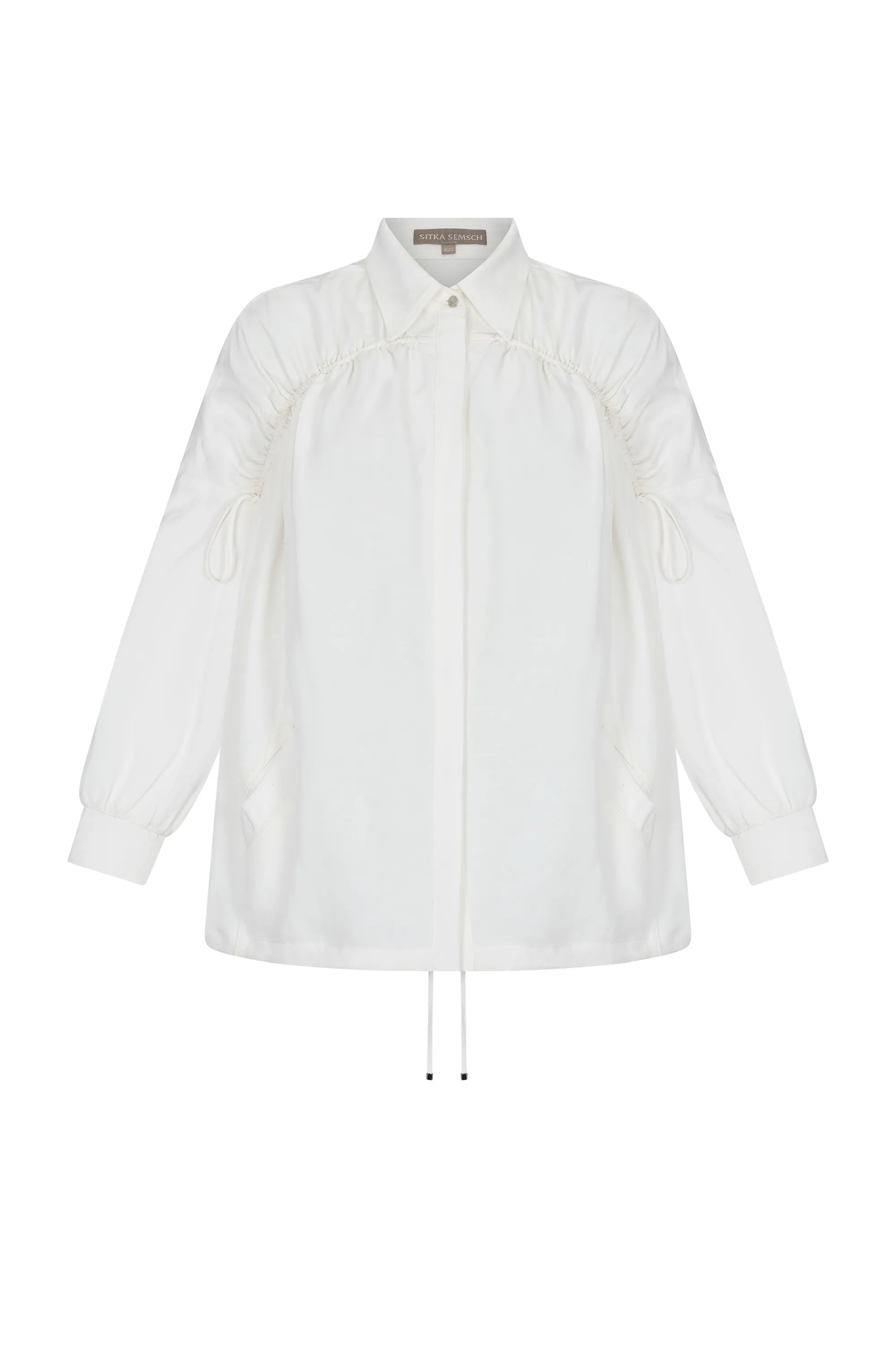 The Ailani Jacket in Off White, highlighting its clean architectural lines and drawstring detail.