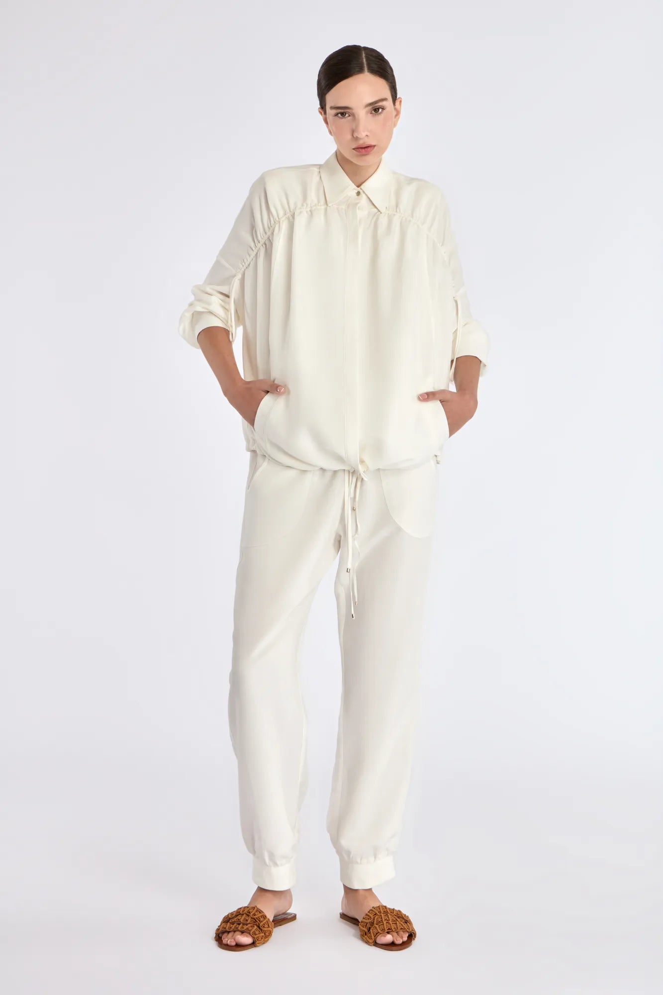 The Ailani Jacket in Off White, highlighting its clean architectural lines and drawstring detail.