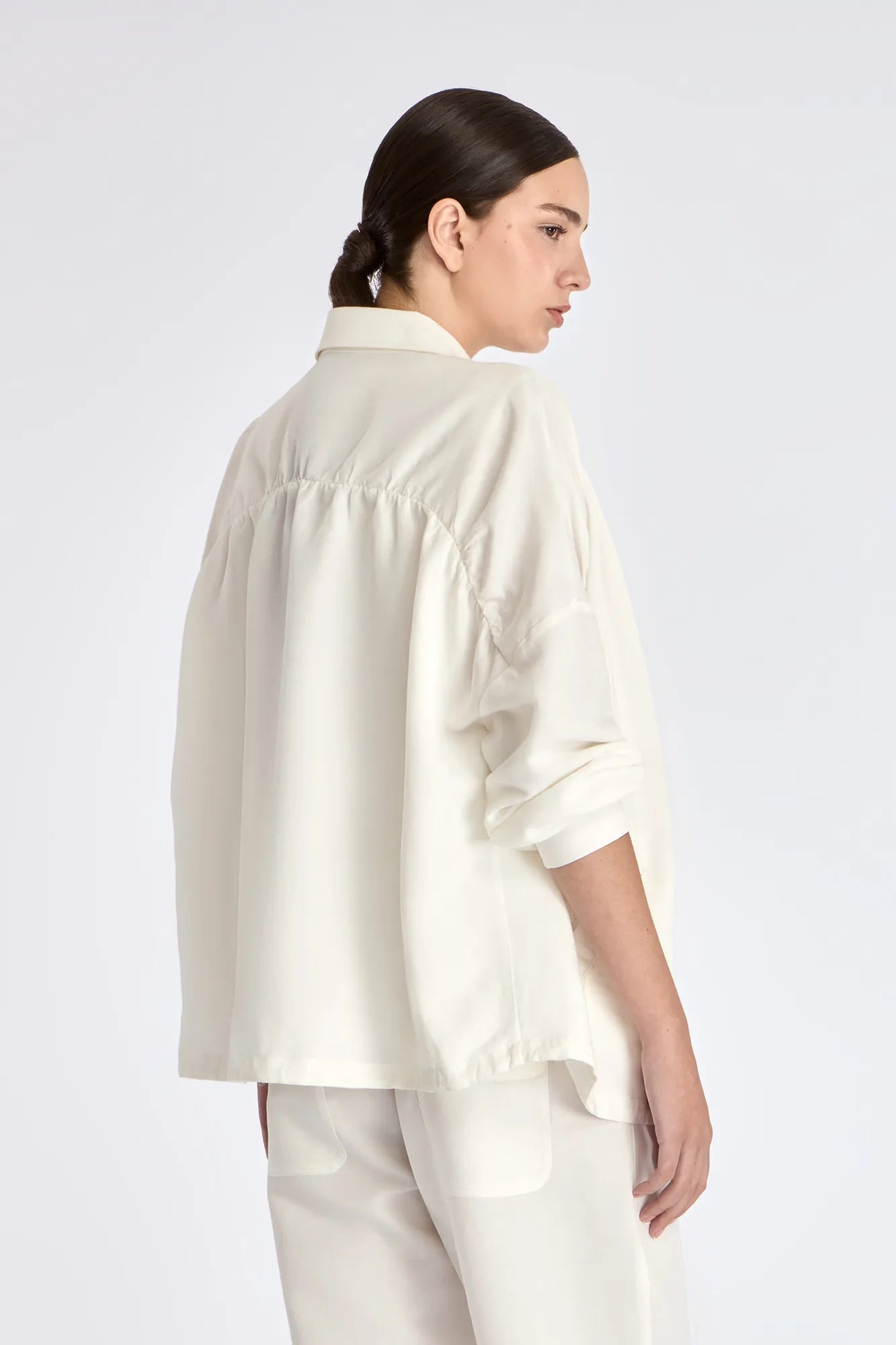 The soft volume of the gathered back panel on the Ailani Jacket in Off White.
