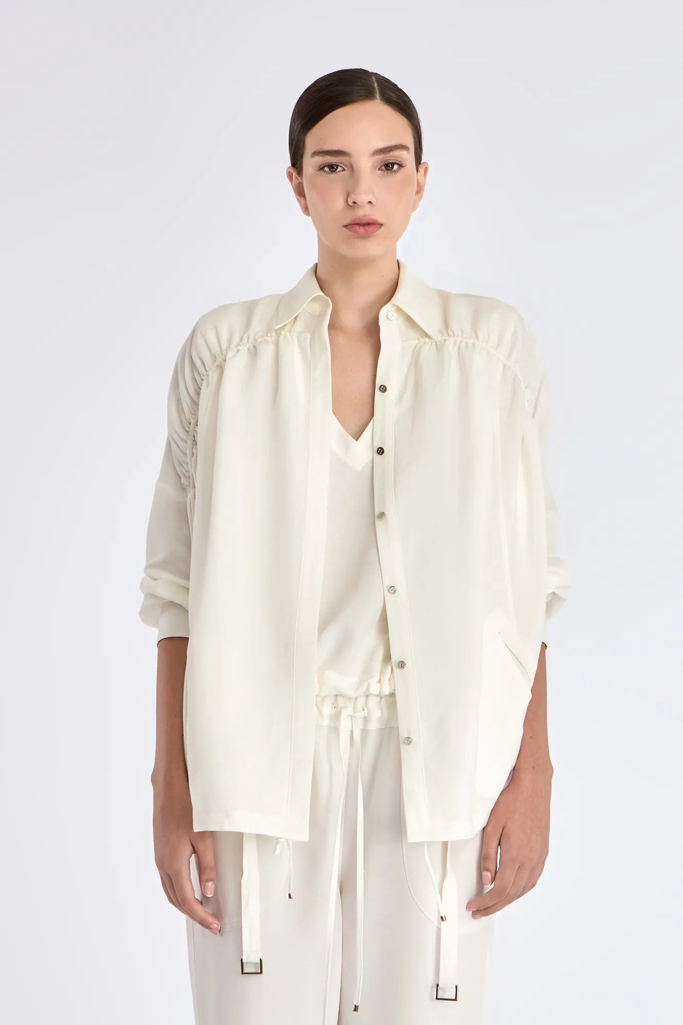 The Ailani Jacket in Off White, highlighting its clean architectural lines and drawstring detail.