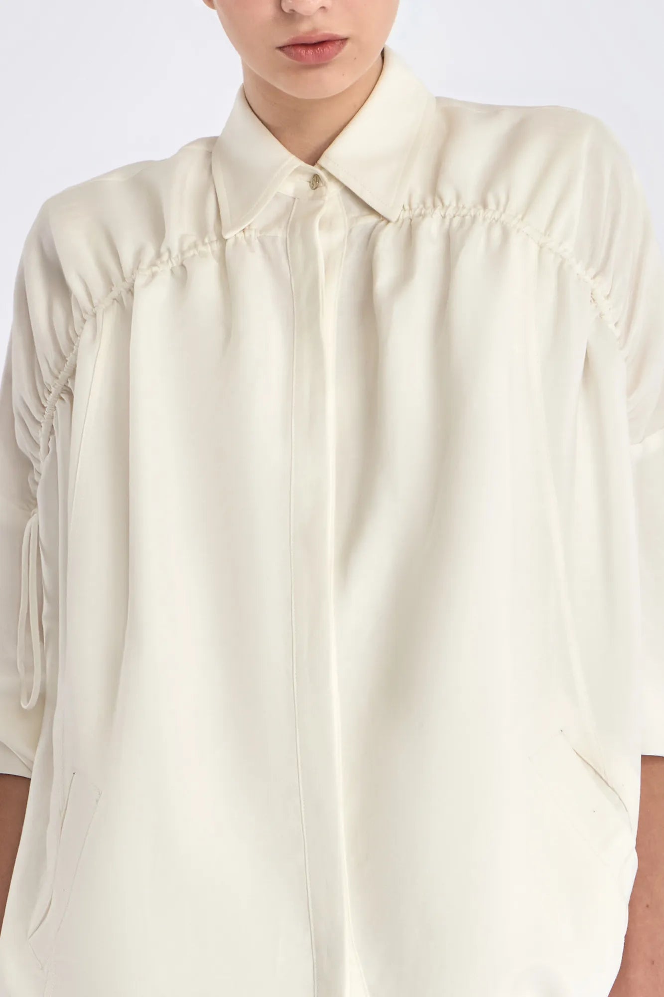Detail shot of the polished metal button and linen blend texture on the Off White Ailani Jacket.
