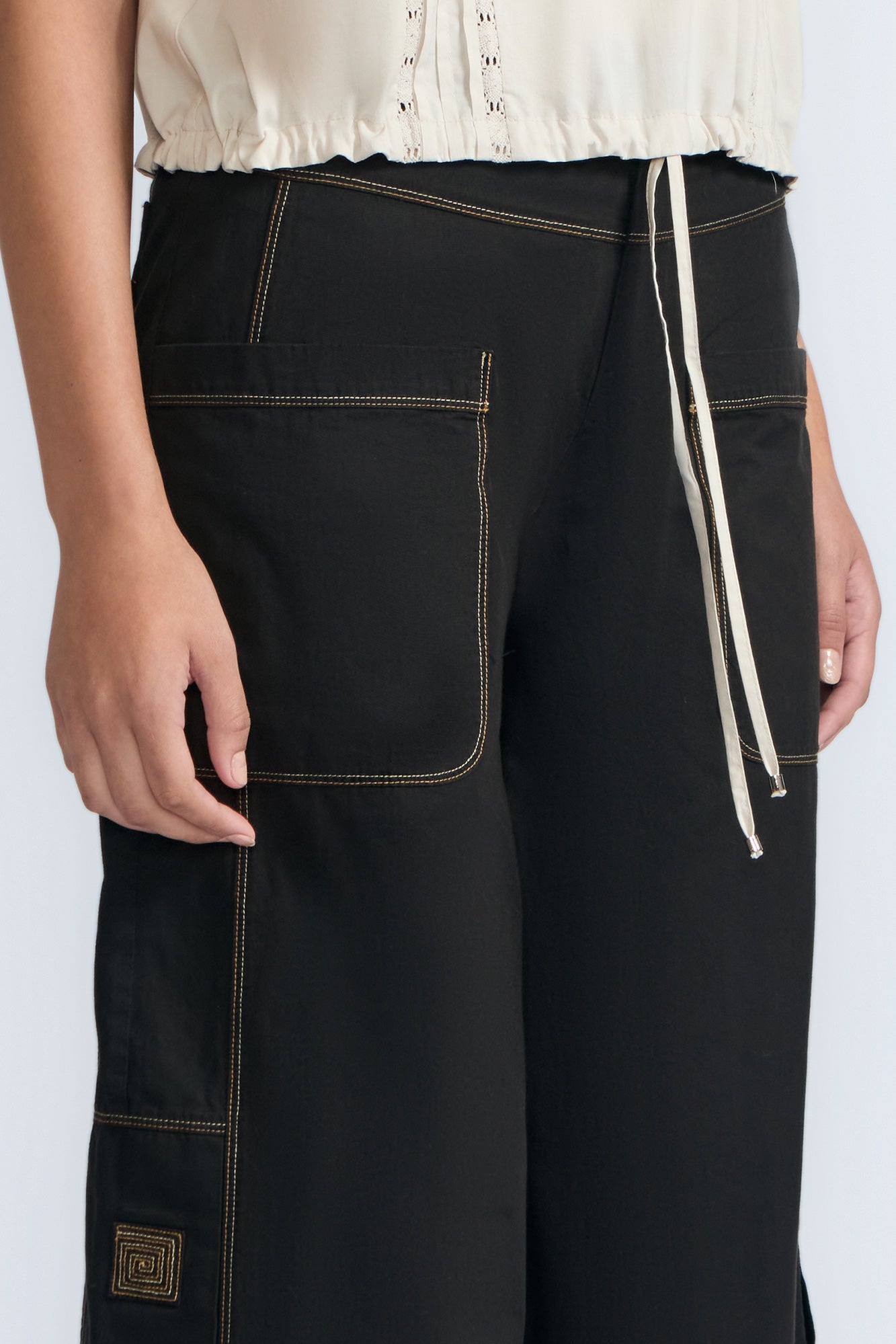 Aliana high-waisted palazzo pants in 100% cotton, featuring front and back patch pockets, side vents with button details, and contrast stitching.