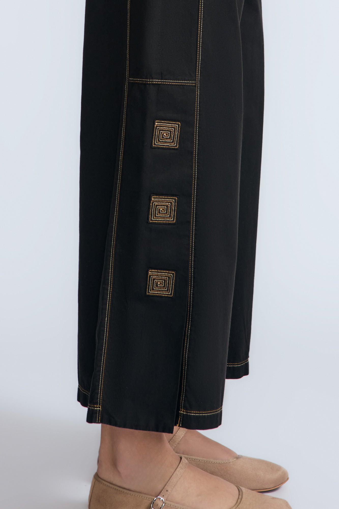 Aliana high-waisted palazzo pants in 100% cotton, featuring front and back patch pockets, side vents with button details, and contrast stitching.