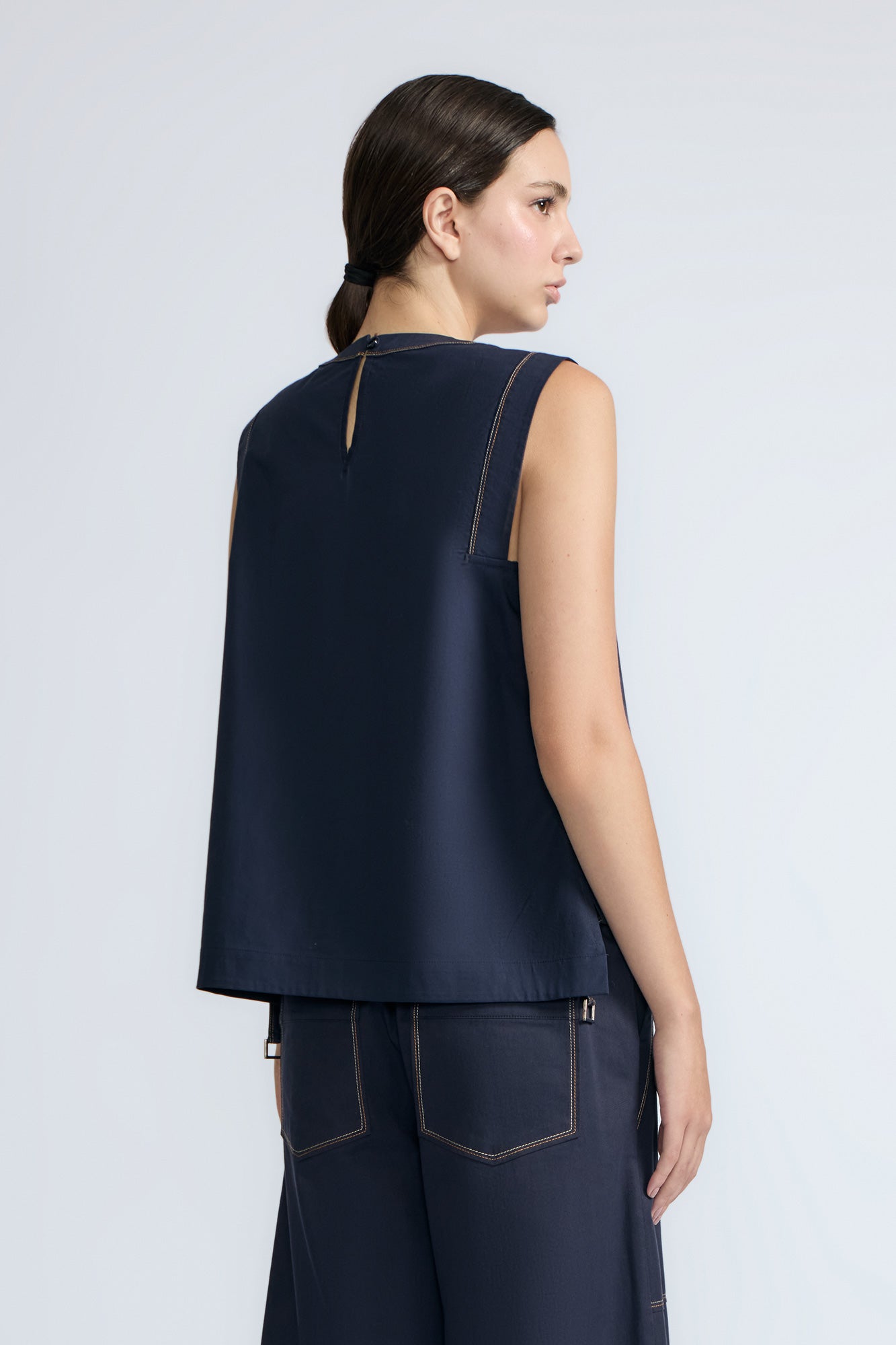 Avayah Top in Navy – 100% cotton sleeveless top with round neckline, shoulder button accents, and drawstring hem.