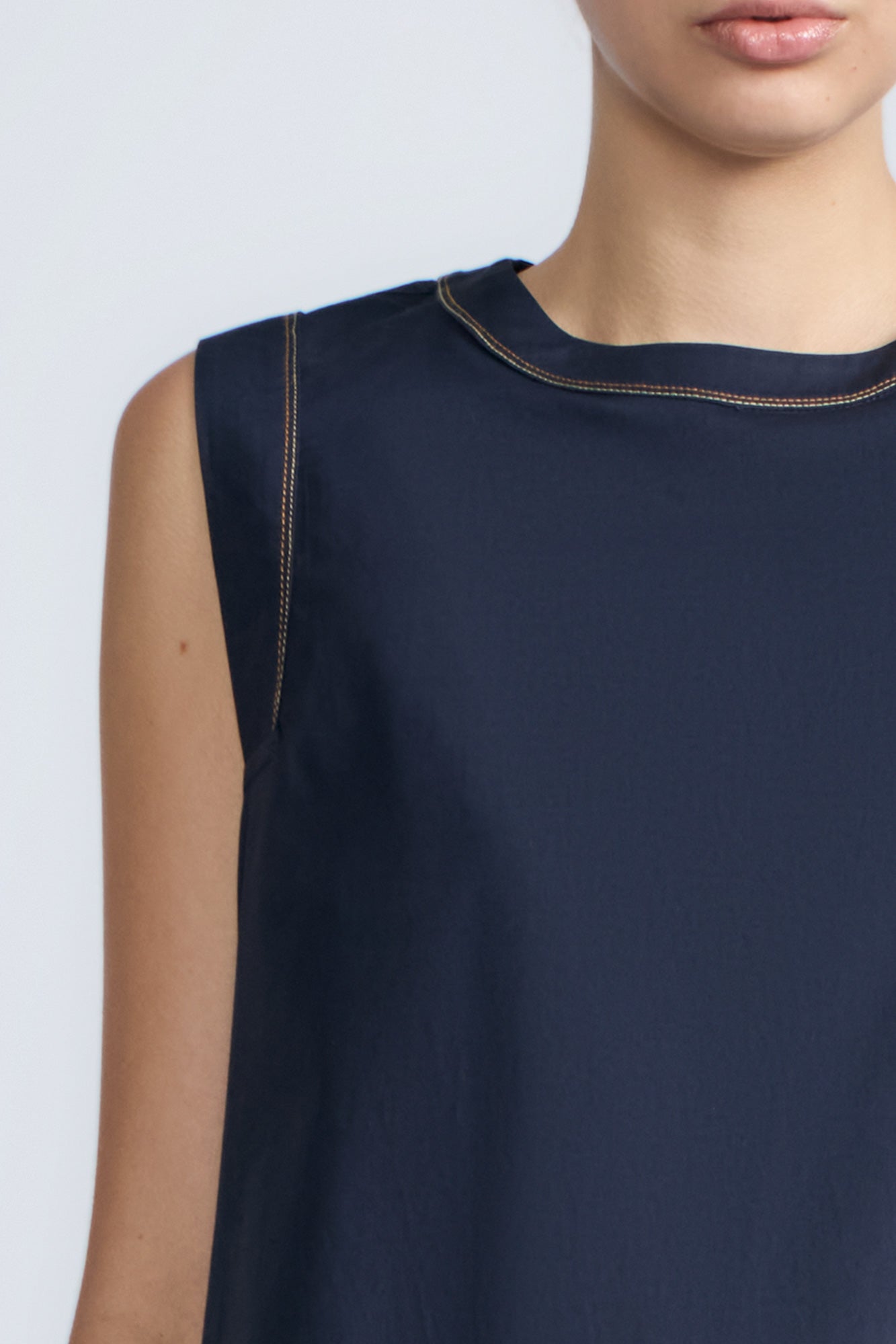 Avayah Top in Navy – 100% cotton sleeveless top with round neckline, shoulder button accents, and drawstring hem.