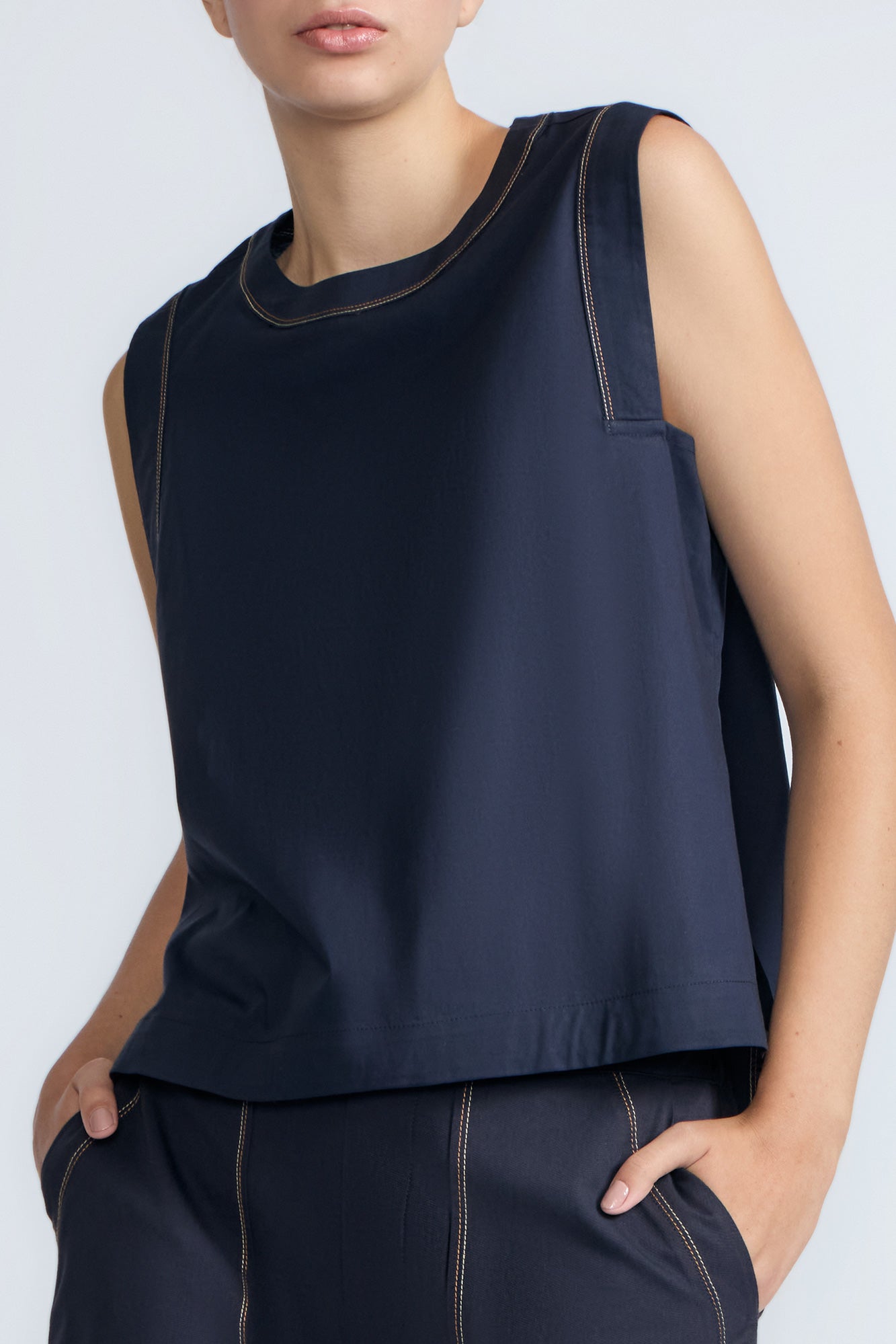 Avayah Top in Navy – 100% cotton sleeveless top with round neckline, shoulder button accents, and drawstring hem.