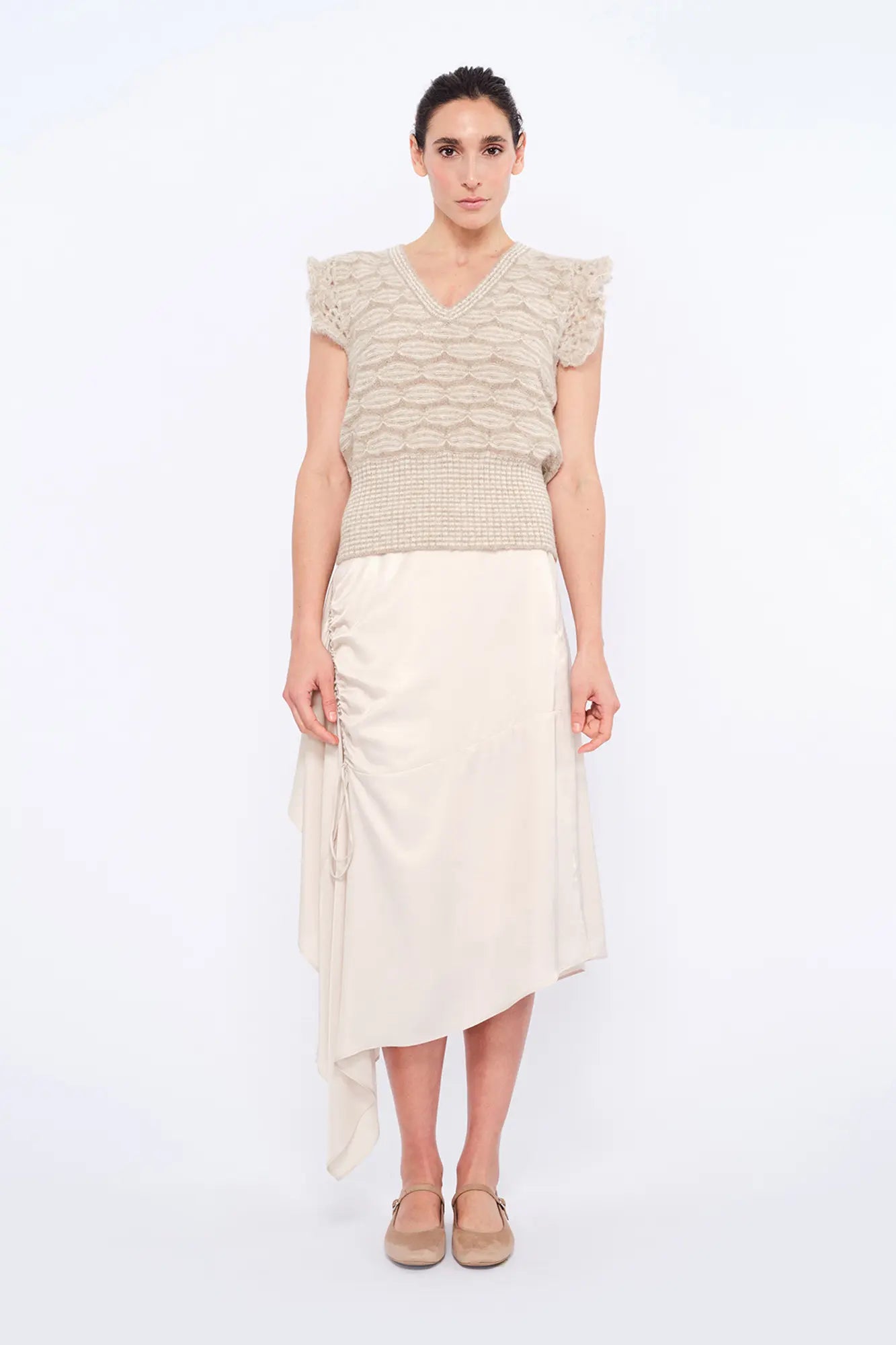 Front view of the Beca Vest in Beige Melange, showcasing the V-neckline and crochet ruffle sleeves.