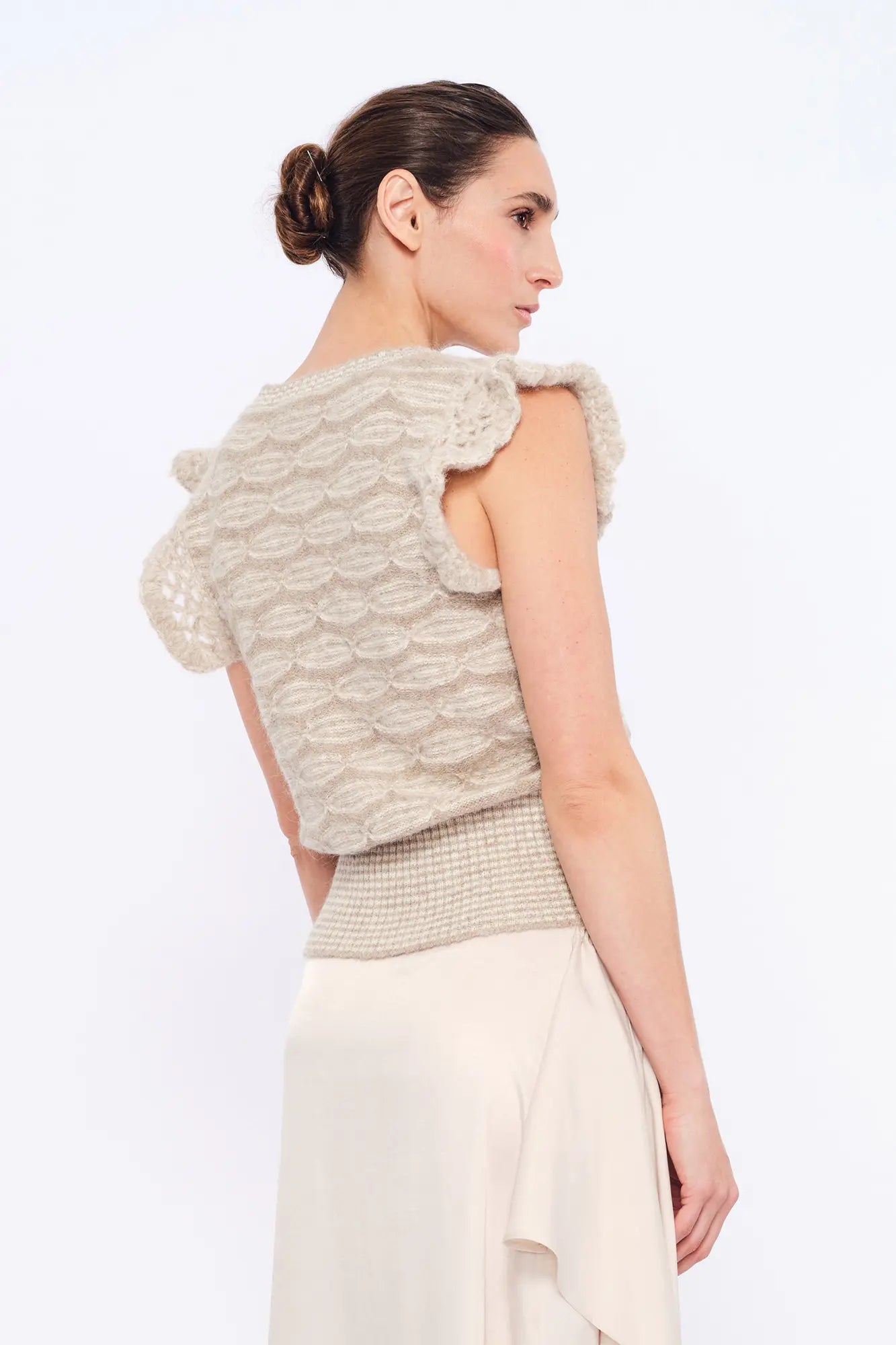 Back view of the Beca Vest, detailing the adjustable woven tie at the nape.