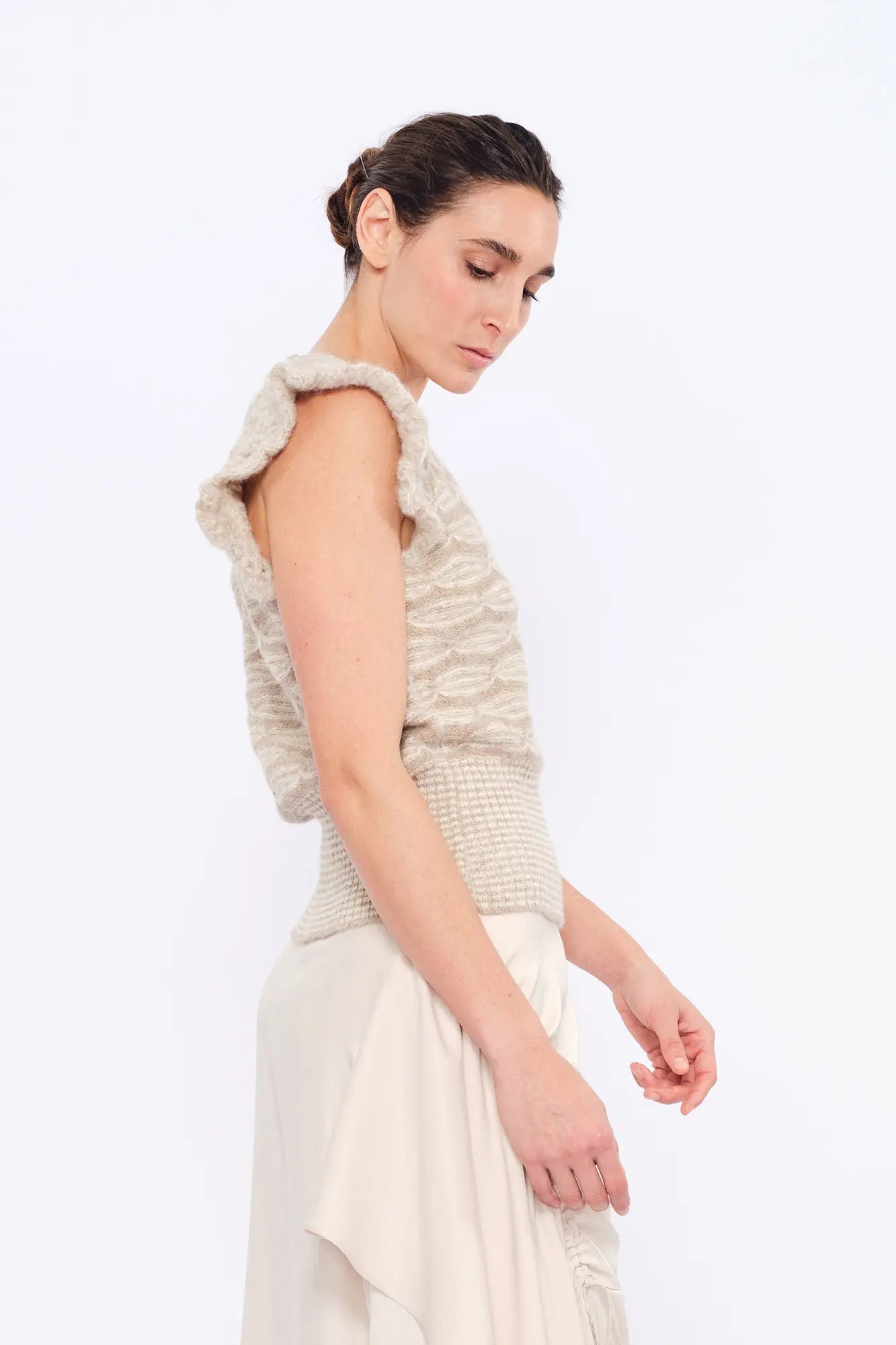 Side profile of the Beige Melange Beca Vest, highlighting the texture of the superfine alpaca knit.