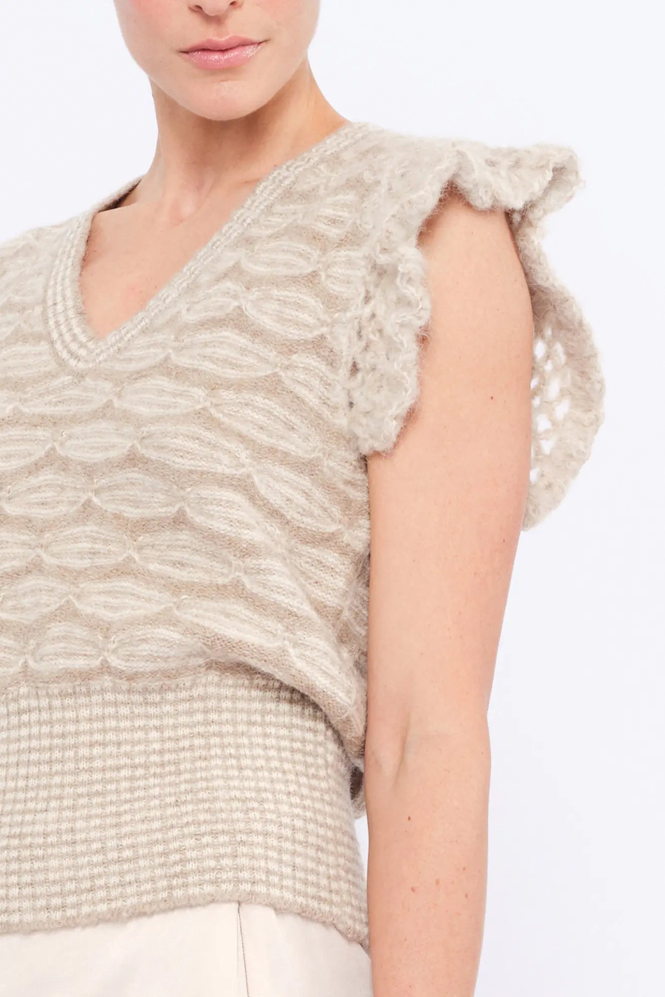 Close-up of the exquisite, handcrafted crochet openwork on the ruffle sleeve of the Beige Melange Beca Vest.