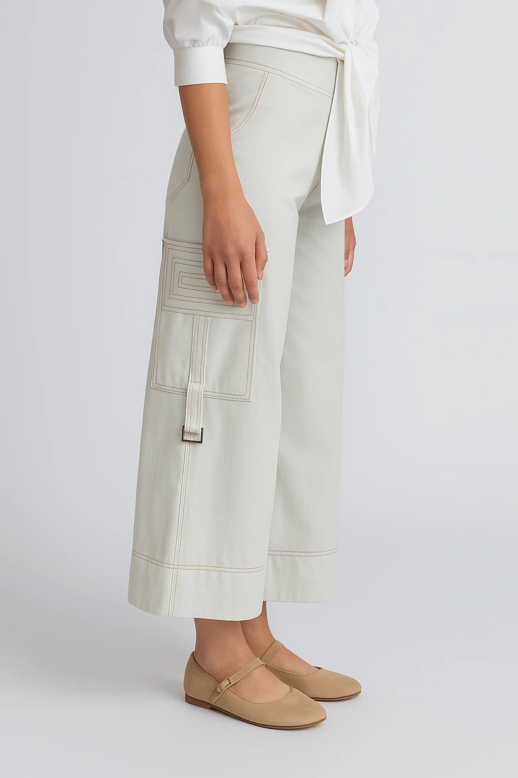 Person wearing light-colored pants and beige shoes on a white background