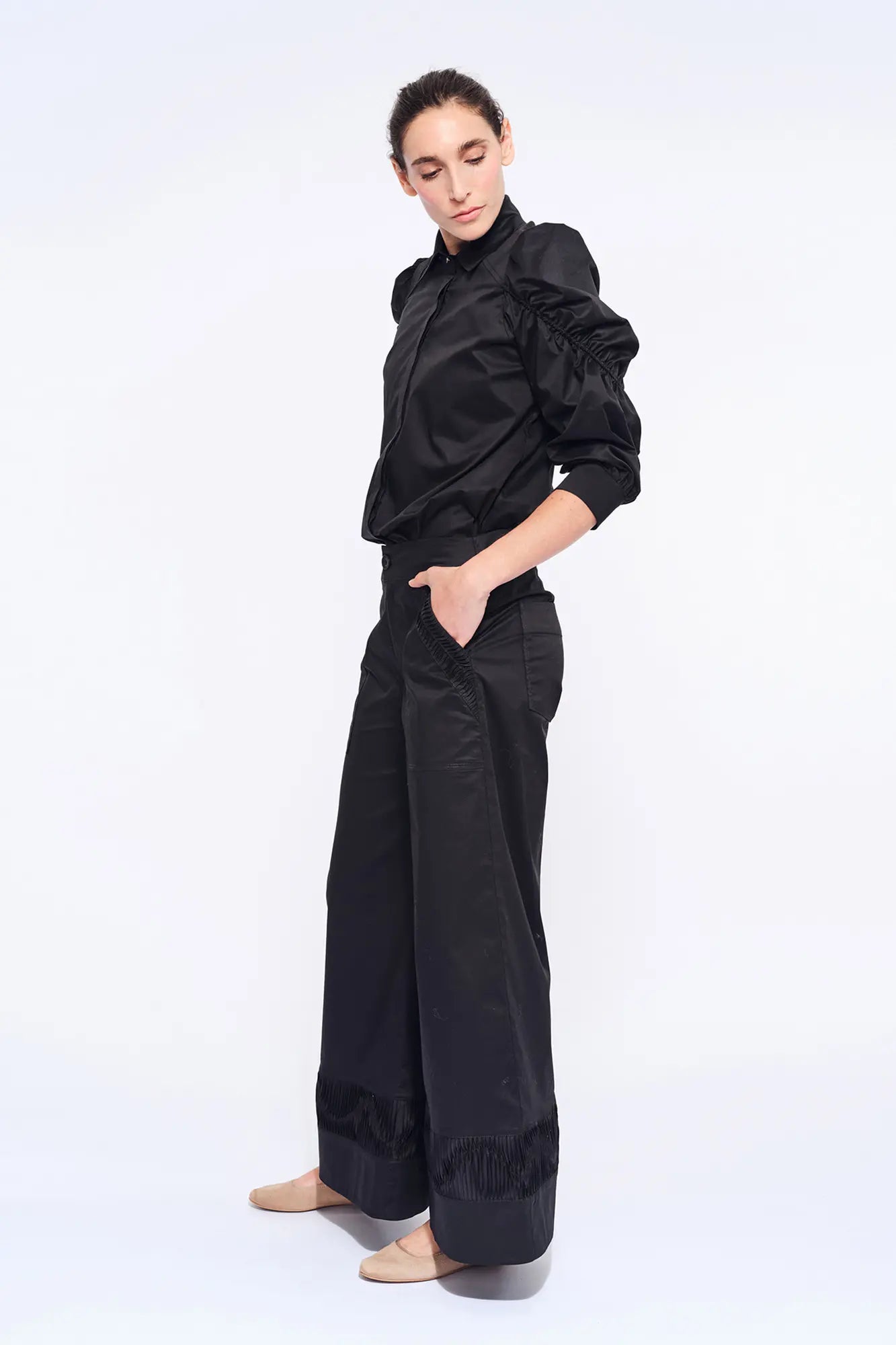 Side profile of the black Bimba Blouse, highlighting the dramatic, sculptural puff sleeves.