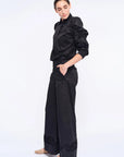 Side profile of the black Bimba Blouse, highlighting the dramatic, sculptural puff sleeves.