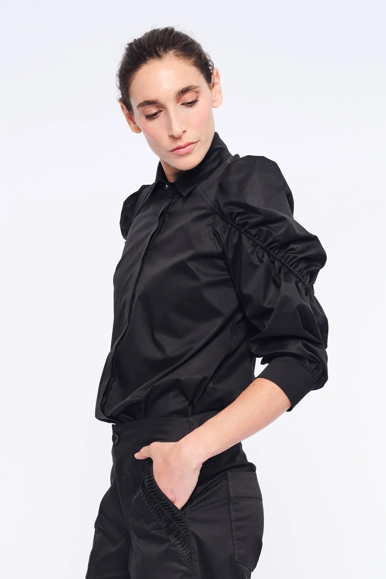 Side profile of the black Bimba Blouse, highlighting the dramatic, sculptural puff sleeves.