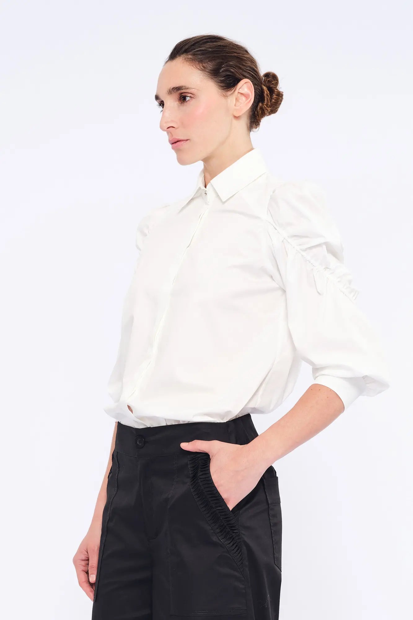 Side view of the white Bimba Blouse, showcasing the soft, romantic volume of its puff sleeves.