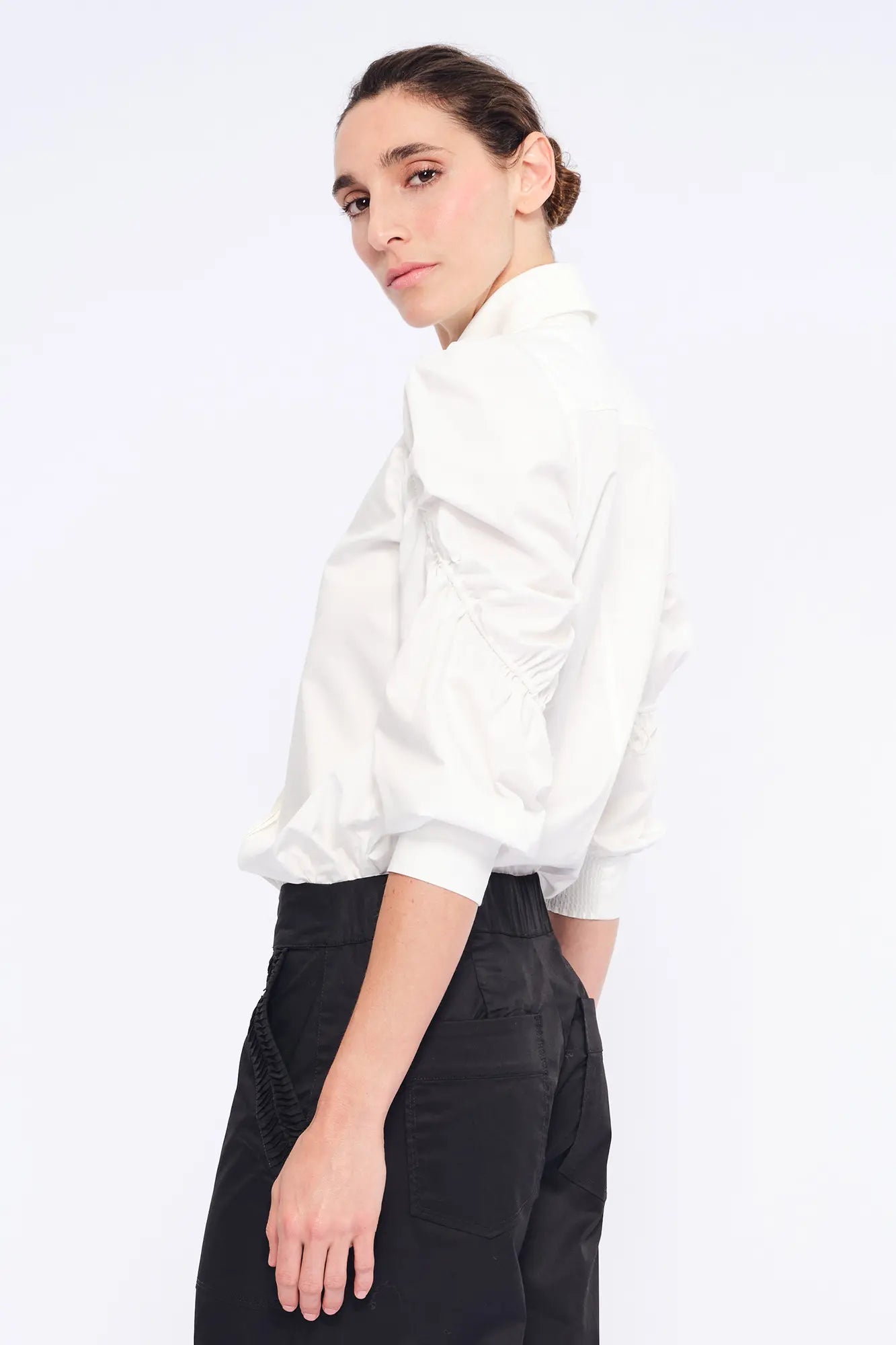 Side view of the white Bimba Blouse, showcasing the soft, romantic volume of its puff sleeves.