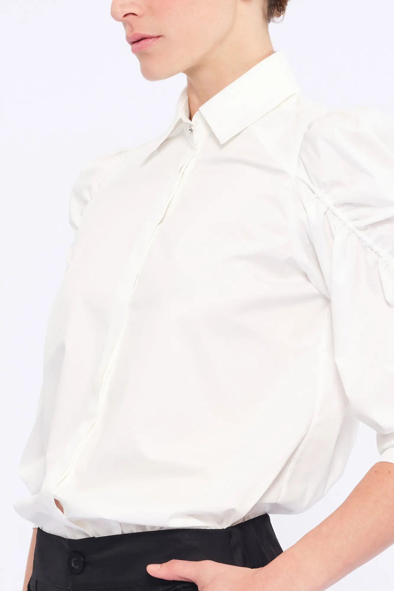 Detail shot of the sculptural puff sleeve and the premium cotton fabric of the white Bimba Blouse.