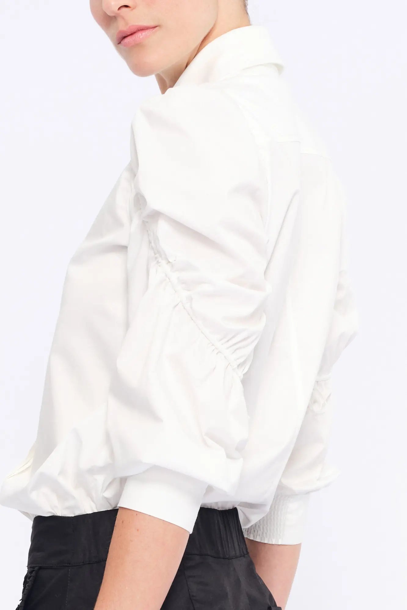Detail shot of the sculptural puff sleeve and the premium cotton fabric of the white Bimba Blouse.