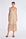 Blake Dress in Nude – Elegant long dress with delicate double straps, V-neck with ruffles, pleated skirt, and hidden side pockets.
