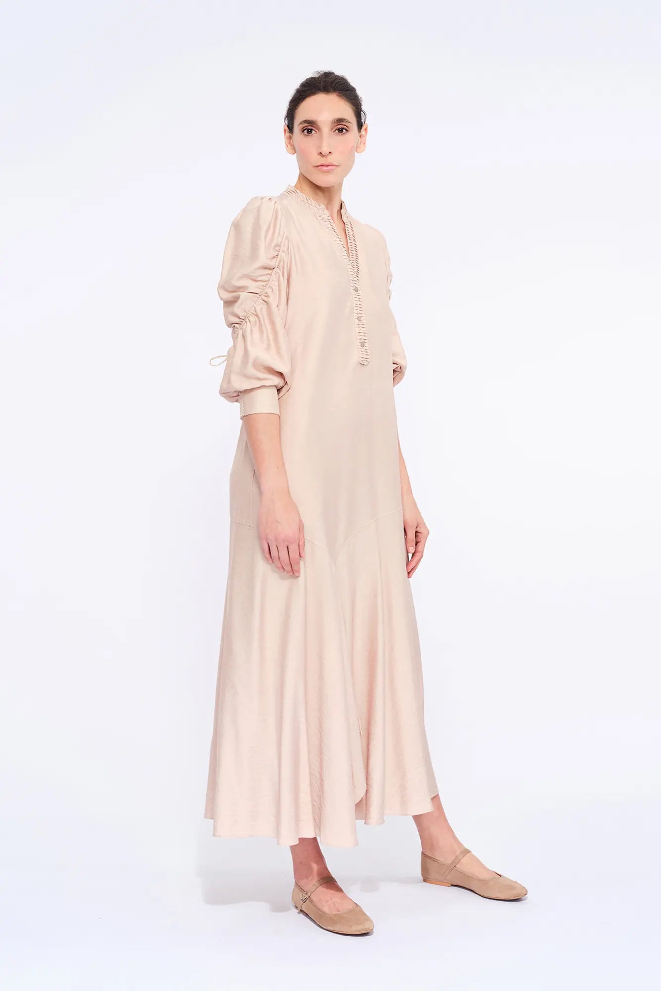 Side profile of the Nude Carlie Dress, highlighting the dramatic volume of the puff sleeves.