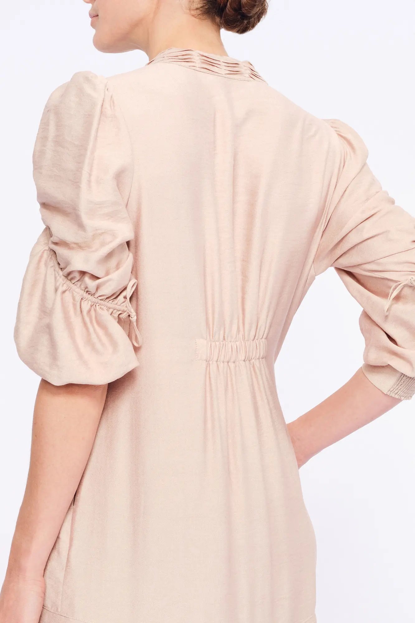 Elegant back silhouette of the Carlie Dress, showing the fluid drape of the fabric.