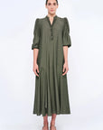 The Carlie Dress in a sophisticated Olive, featuring its soft puff sleeves and draped skirt.