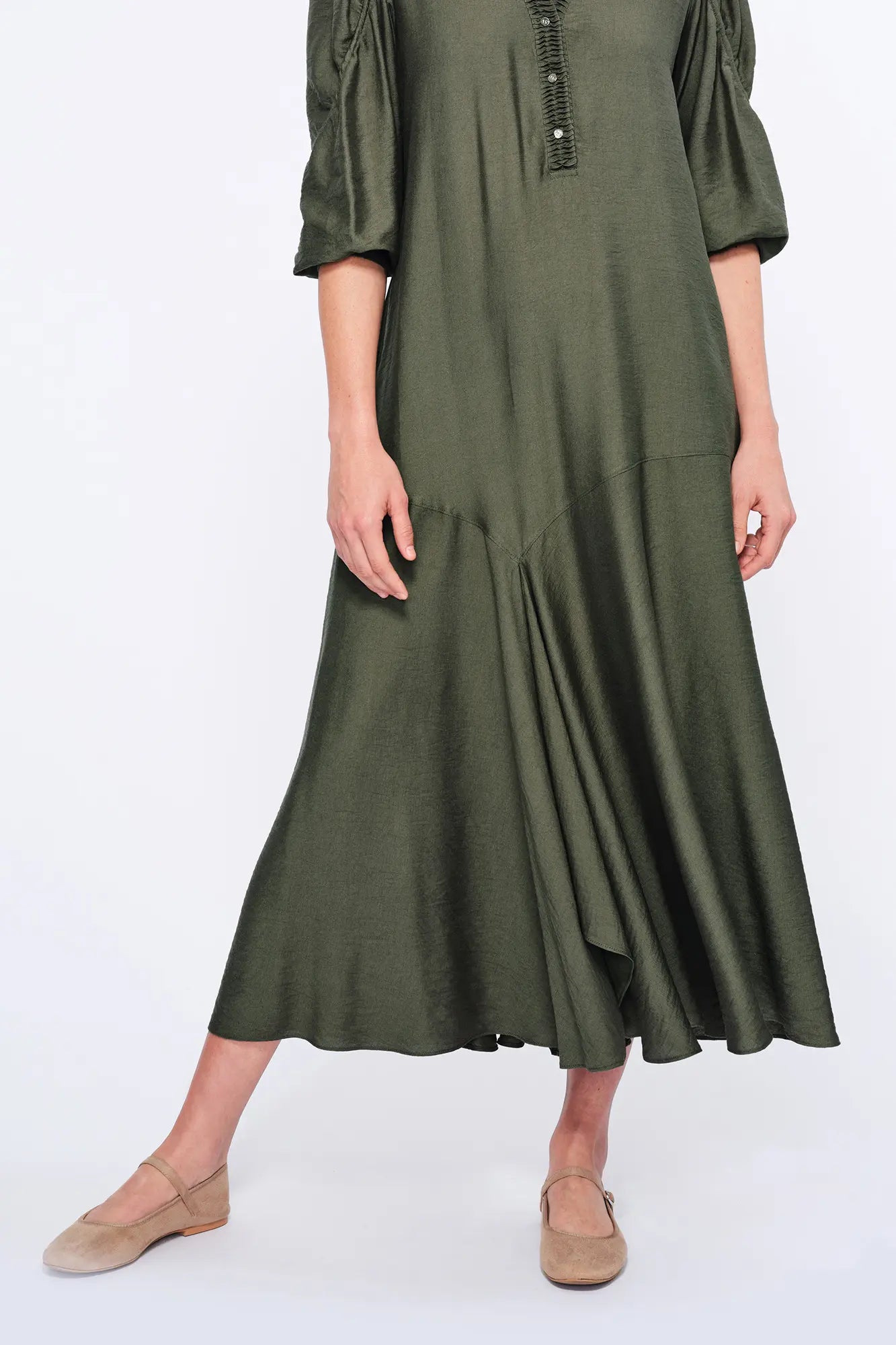 The Carlie Dress in a sophisticated Olive, featuring its soft puff sleeves and draped skirt.