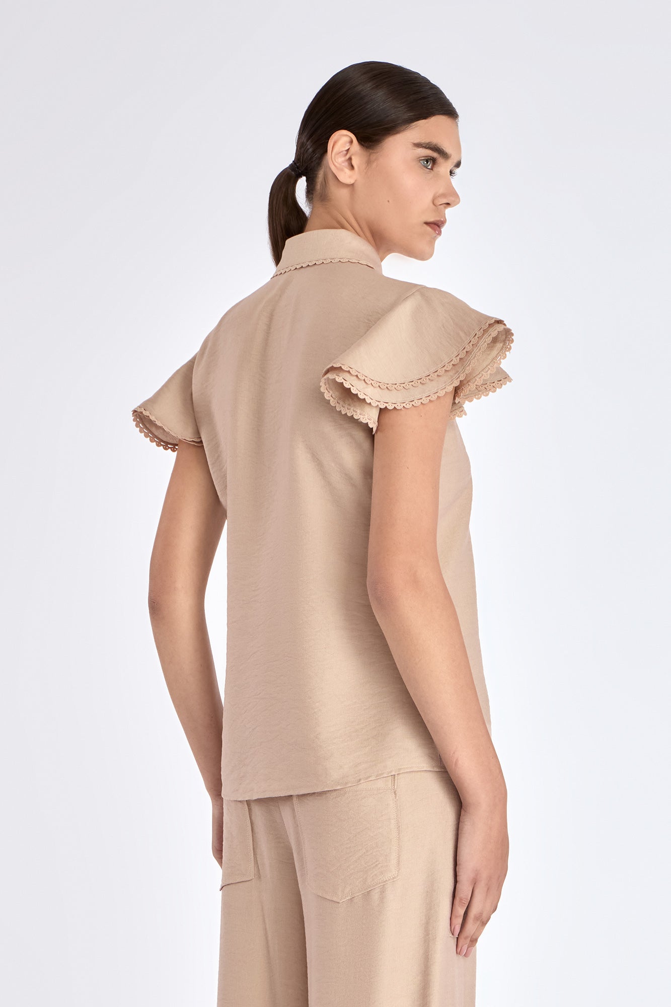 Clark Blouse in Nude – Rayon-blend shirt collar blouse with hidden placket, short ruffled sleeves, and tonal detailing.