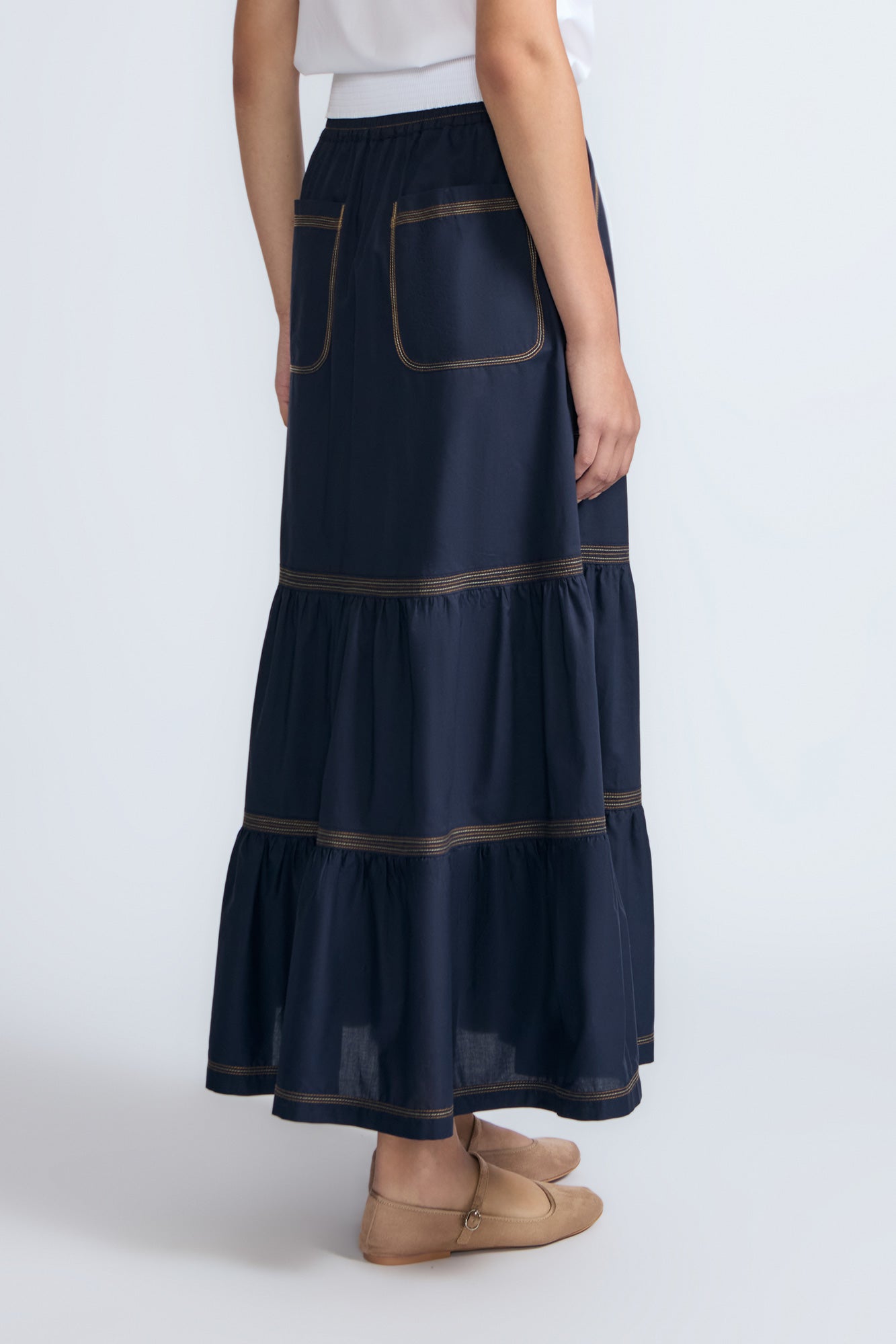Eden Skirt in Navy – Cotton midi skirt with ruffled hem, front patch pockets, and elasticized back waistband.