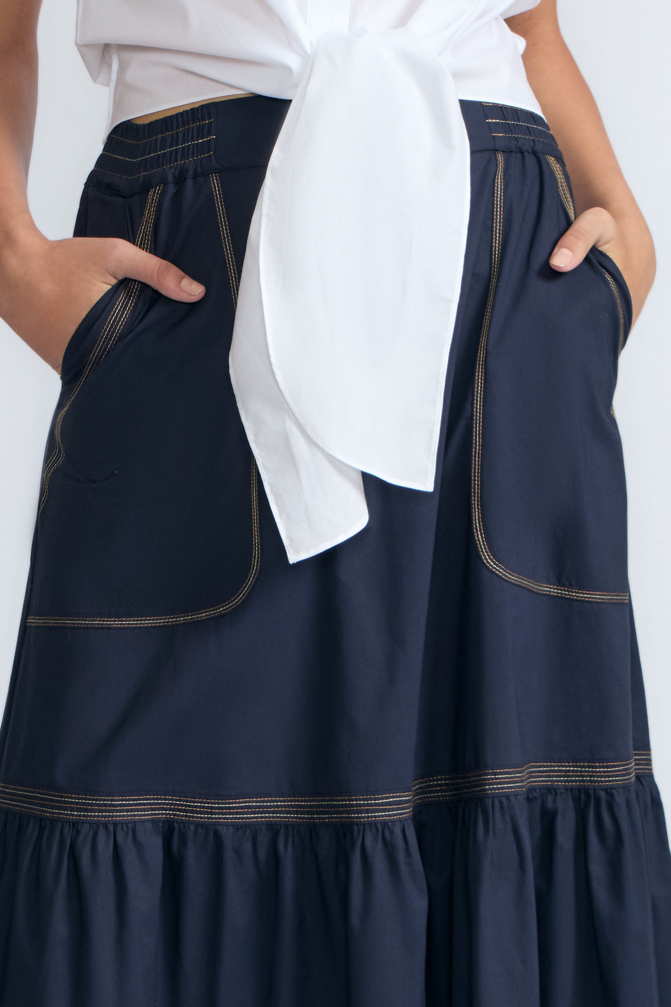 Eden Skirt in Navy – Cotton midi skirt with ruffled hem, front patch pockets, and elasticized back waistband.