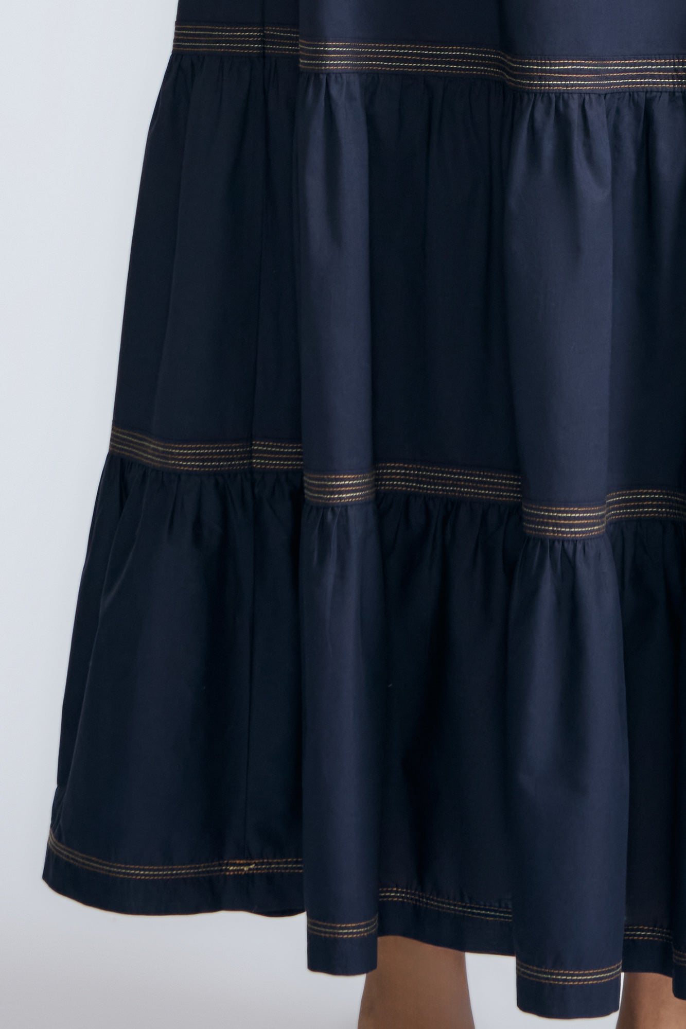 Eden Skirt in Navy – Cotton midi skirt with ruffled hem, front patch pockets, and elasticized back waistband.