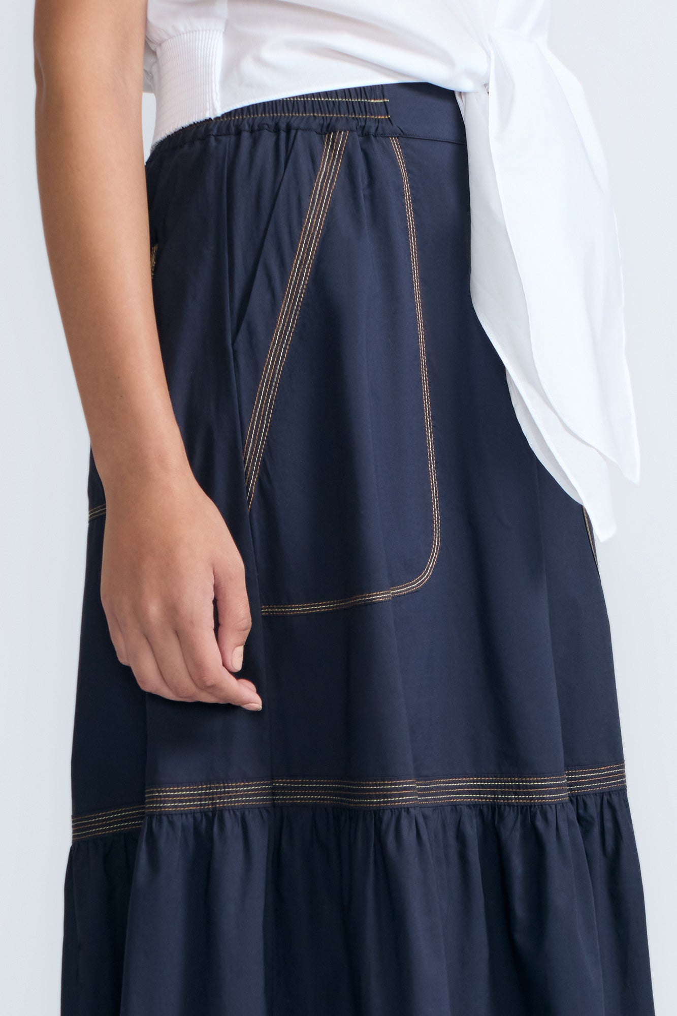 Eden Skirt in Navy – Cotton midi skirt with ruffled hem, front patch pockets, and elasticized back waistband.