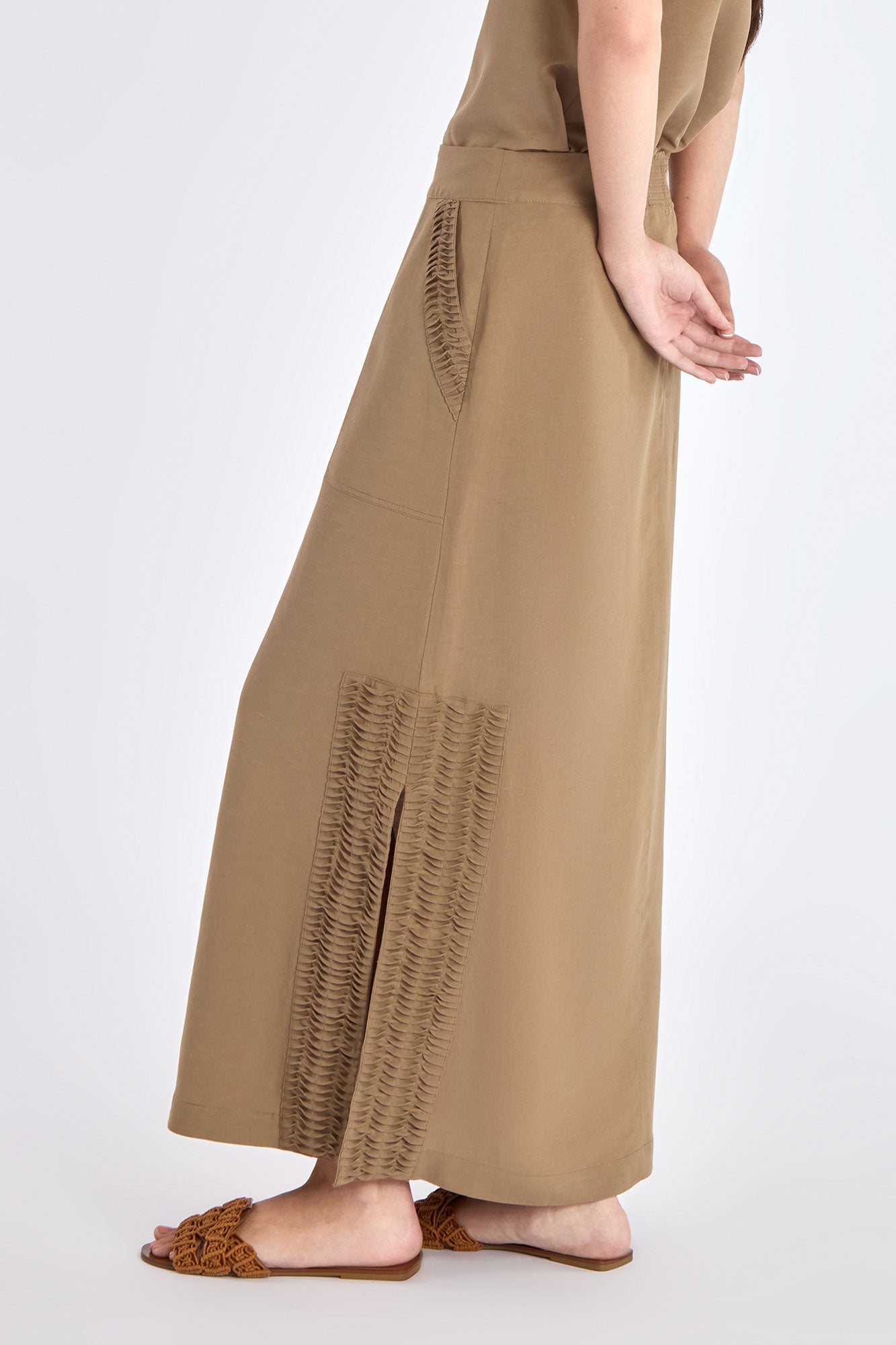 Side profile of the Taupe Indigo Skirt, highlighting the clean silhouette and subtle side slit detail.
