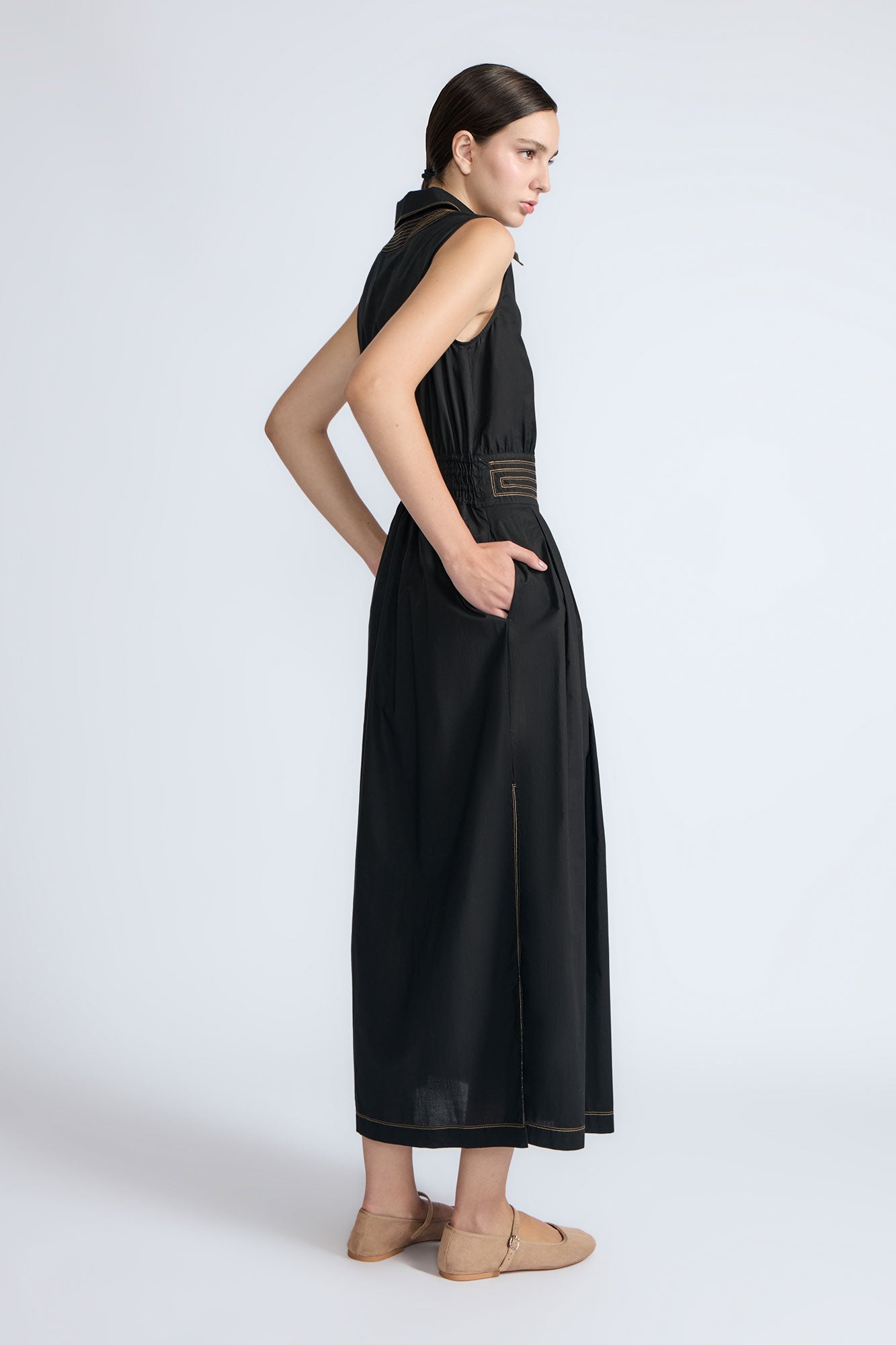 Isidora Dress in Black – Sleeveless midi cotton dress with shirt collar V-neckline, tiered silhouette, and hidden side pockets.
